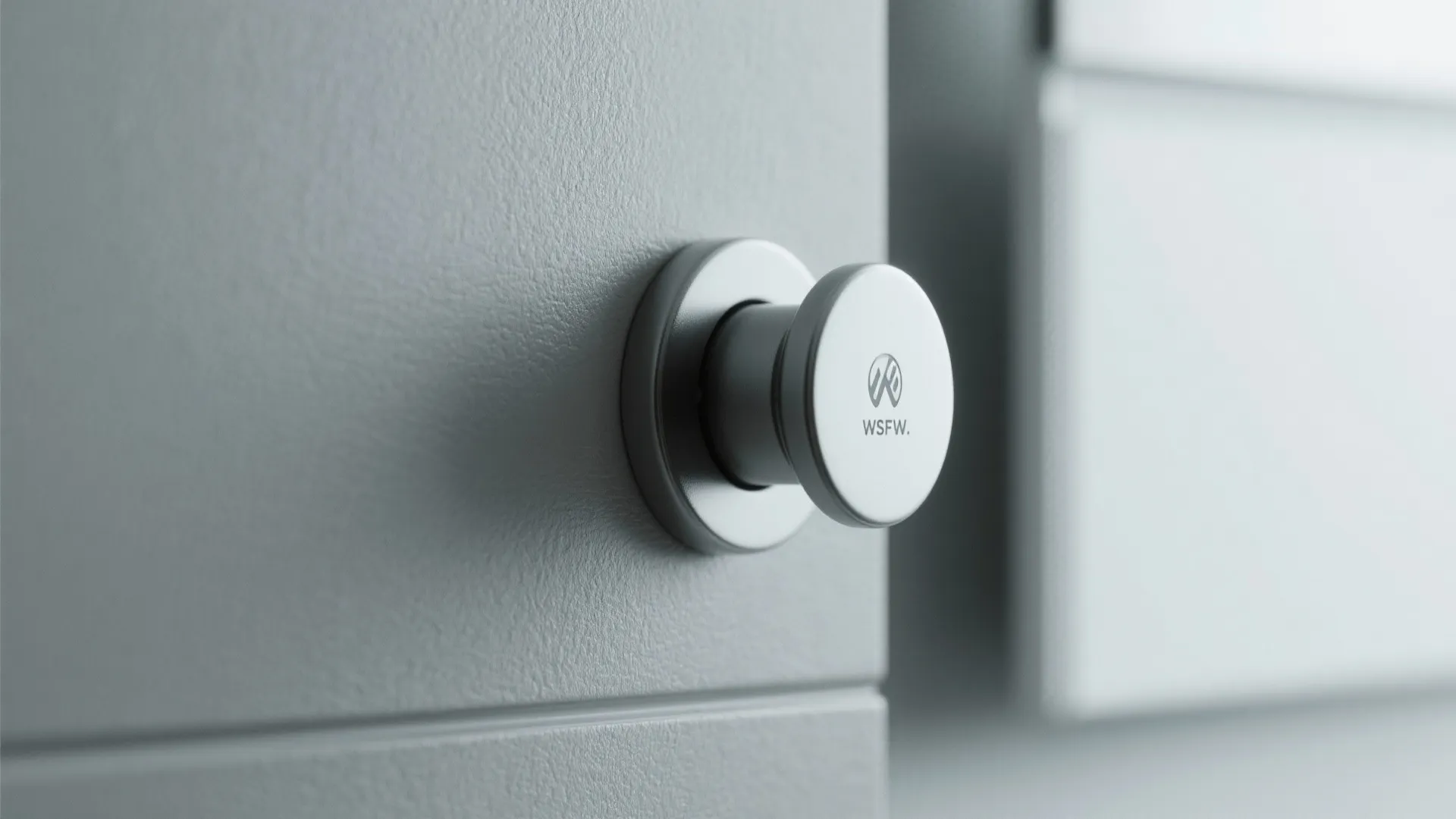 Close up of small circular white magnetic knob installed on modern grey cabinet door surface