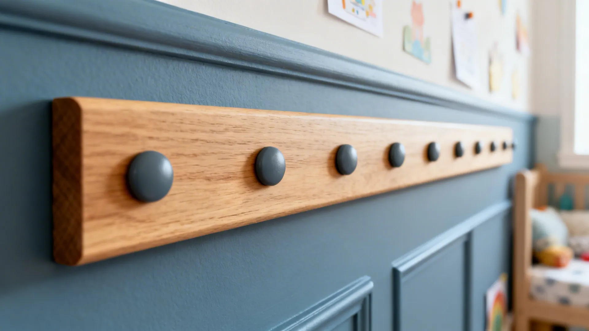 Close-up of an oak-covered magnetic strip with matte magnets on a dusty blue wall.