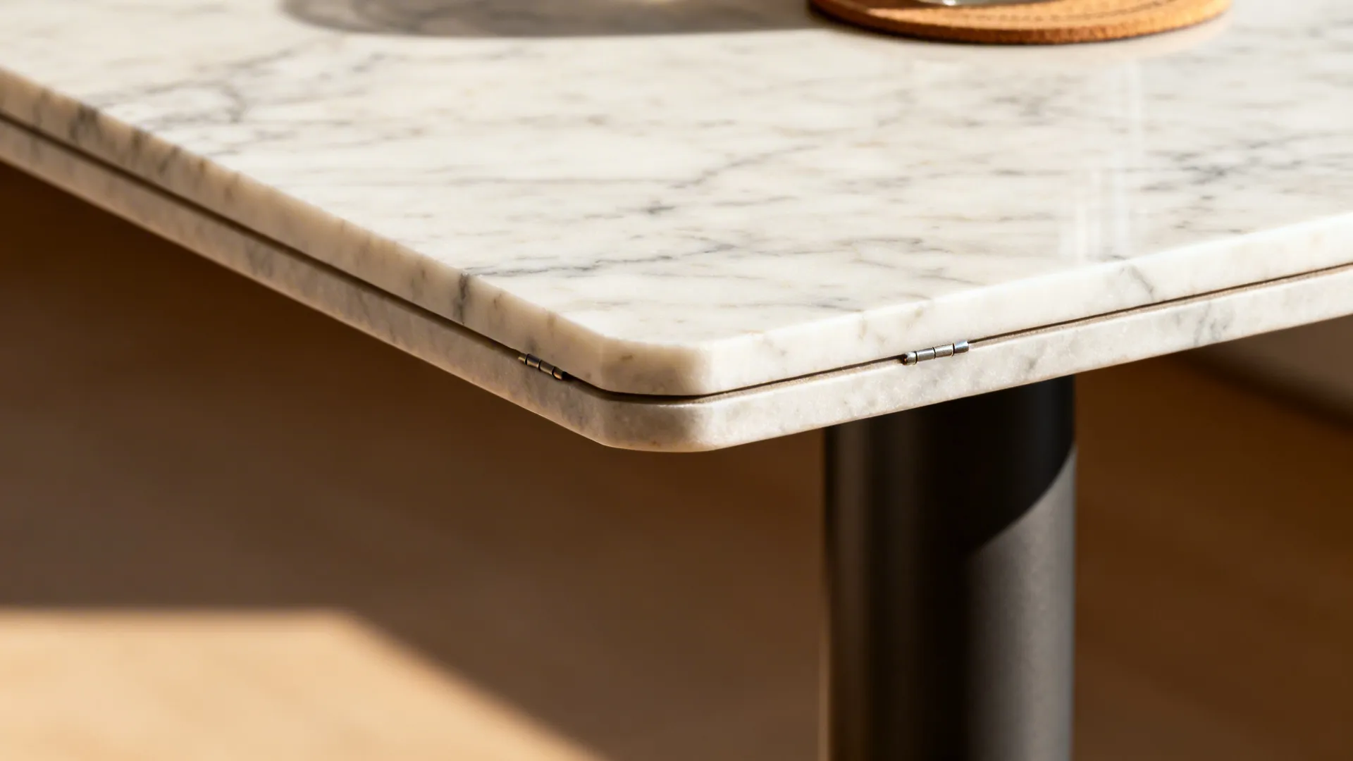 Macro of marble bevel and powder-coated pedestal junction with natural veining.