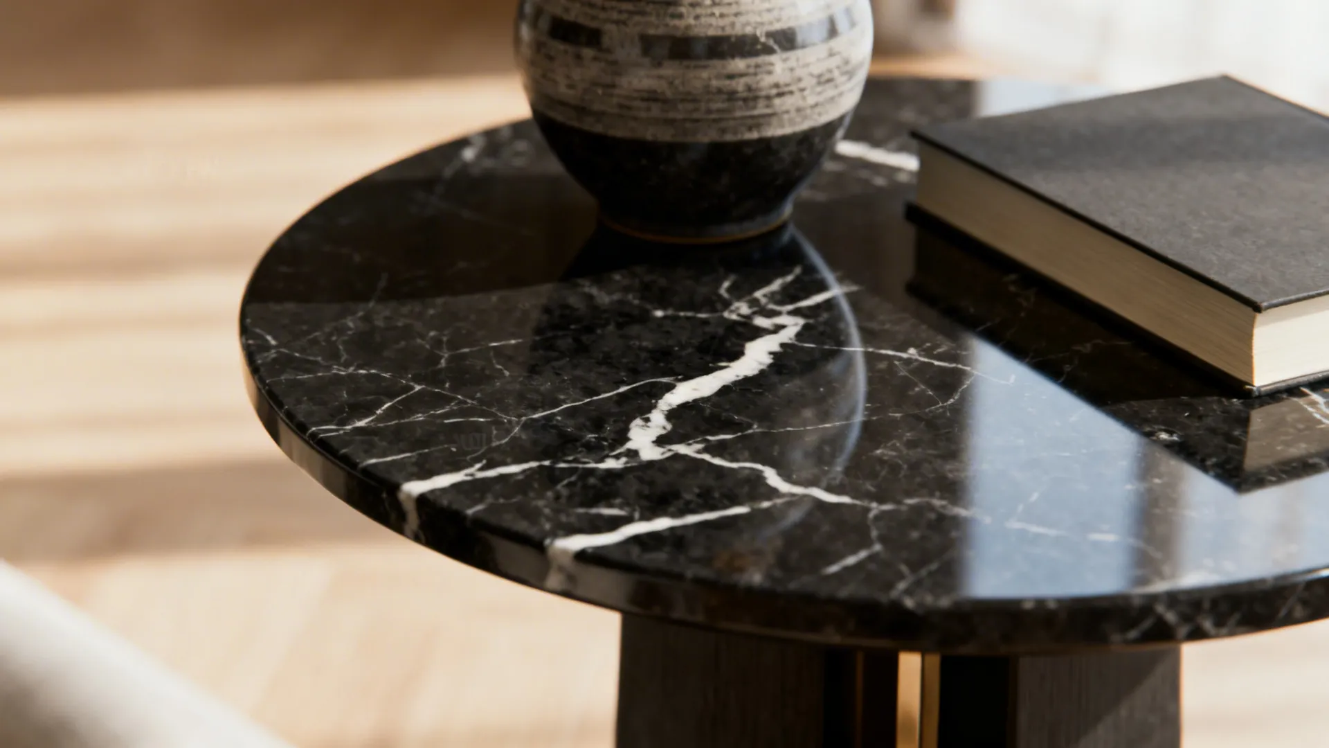 Close-up of black marble-top end table showing detailed veining and reflective surface.
