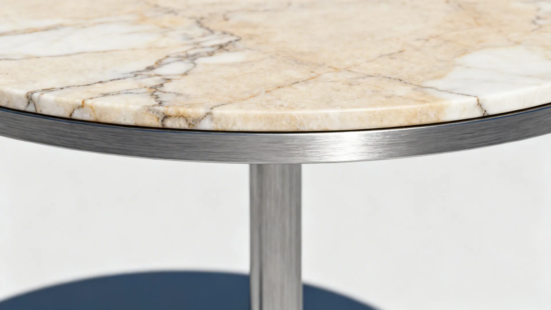 Close-up of a marble top on a thin metal base, showing material contrast and joinery.