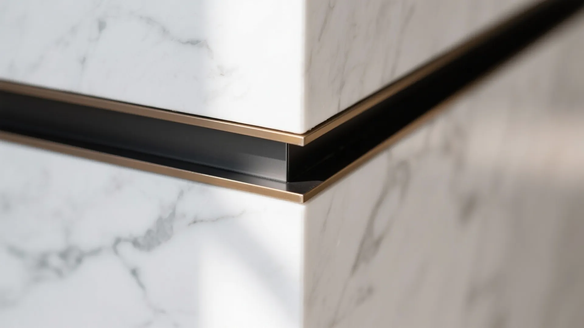 Close up of white marble wall corner with a black and bronze metal trim detail
