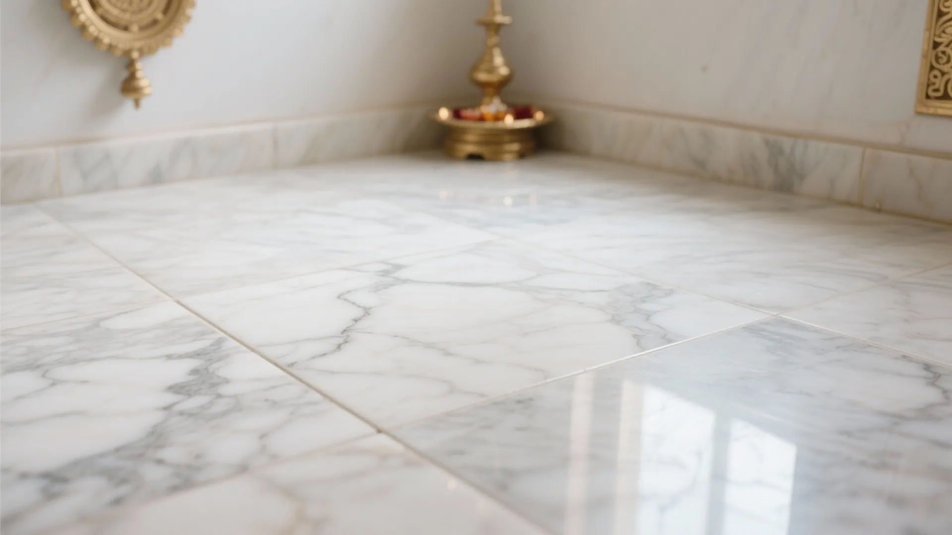 Close up view of white marble floor tiles with grey veins and golden room decor