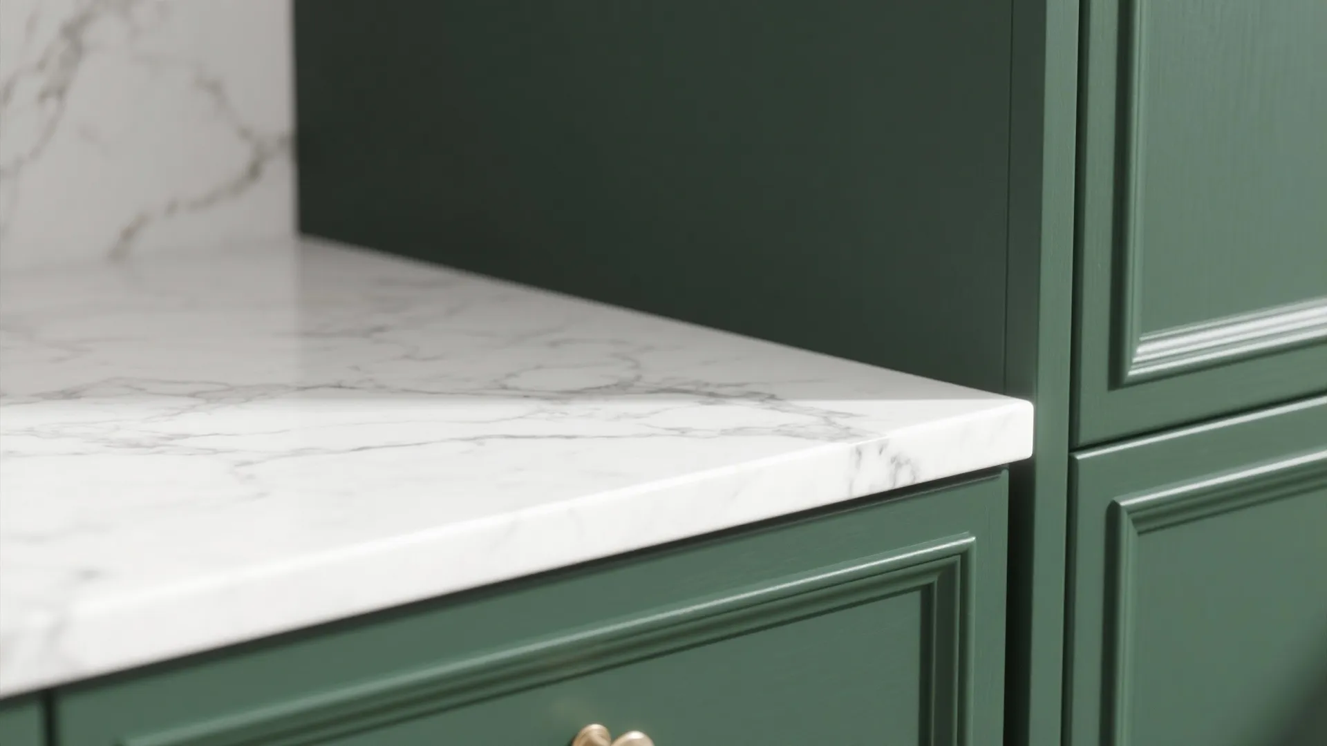 Close up of white marble countertop paired with dark green kitchen cabinet with gold metal handle