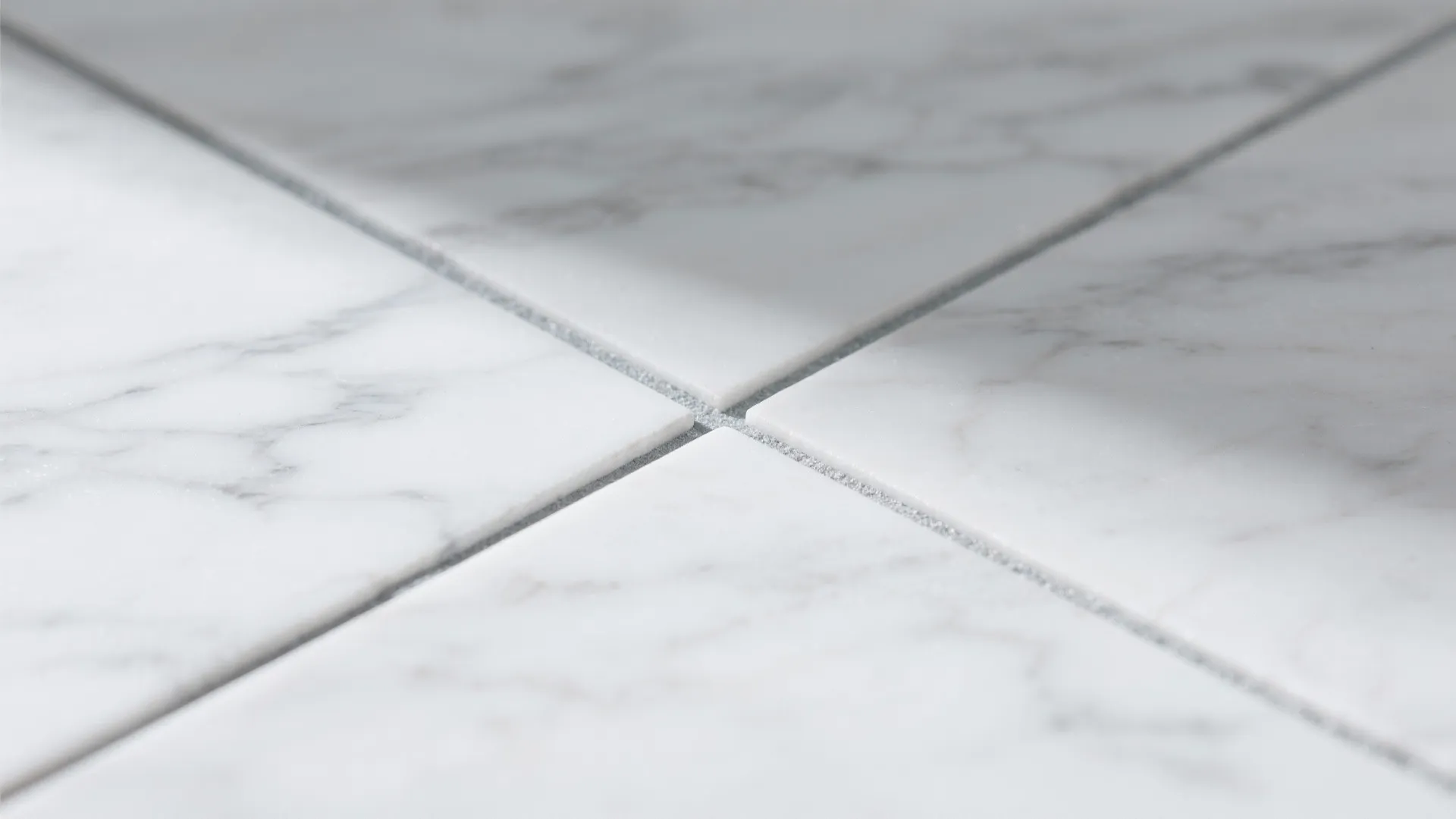 Macro of polished white marble with gentle gray veining and neat grout.