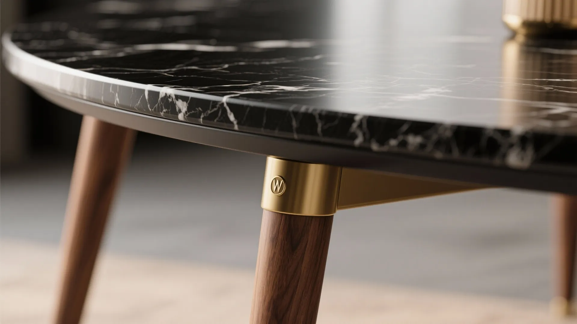Detail of round black marble table top with white veins gold metal and wooden legs