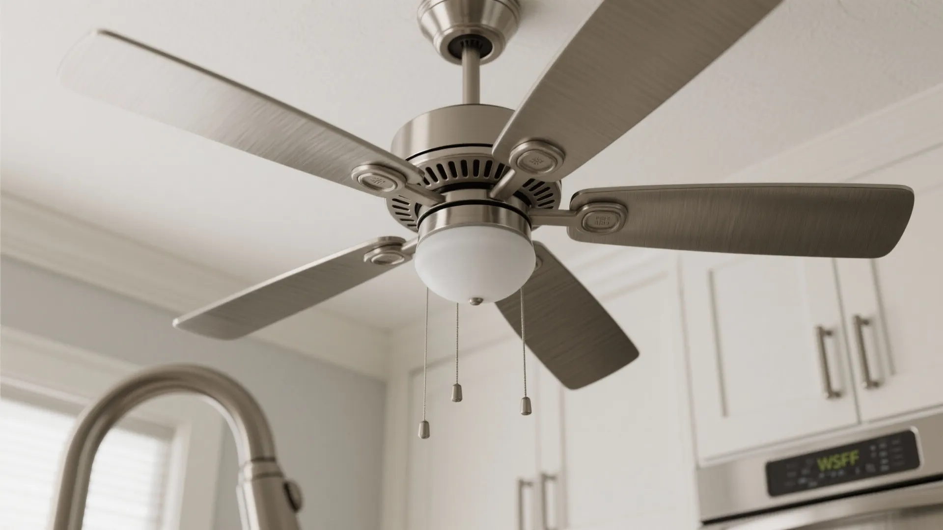 Close-up of brushed nickel kitchen ceiling fan matching hardware