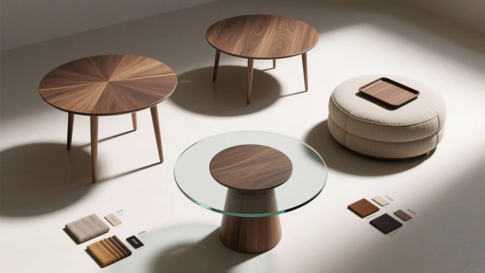 Modern wood coffee tables and round footrest with fabric material samples on a white floor