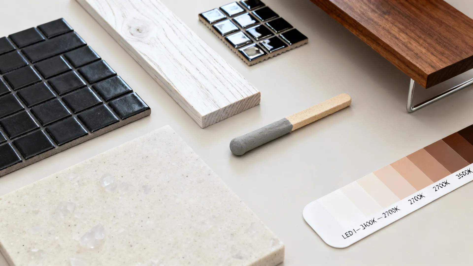 Flatlay with black tile samples, white oak, walnut, pale quartz, and warm gray grout.