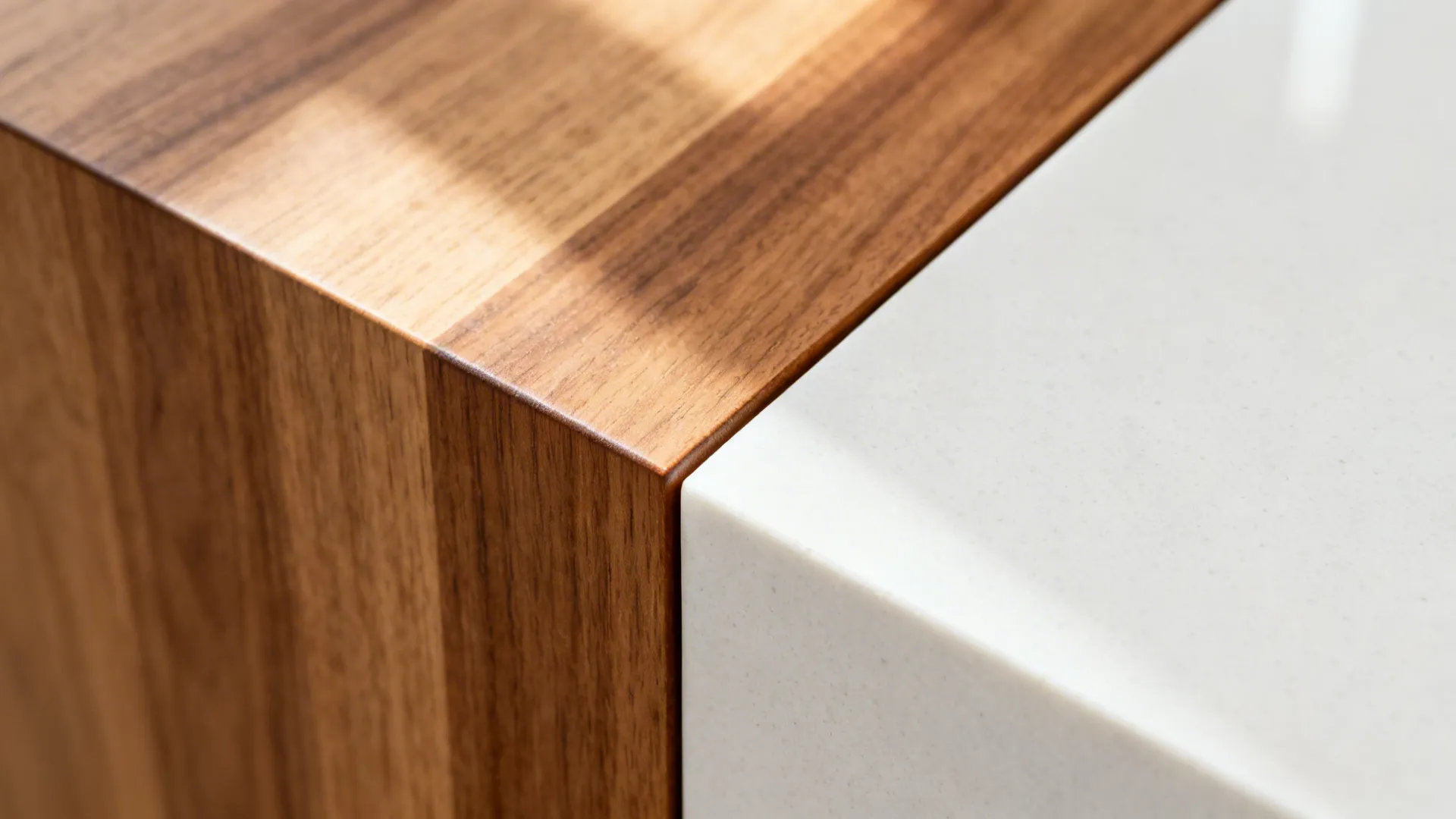 Close-up of a micro-bevel where warm oak meets matte white quartz on a T-shaped island.