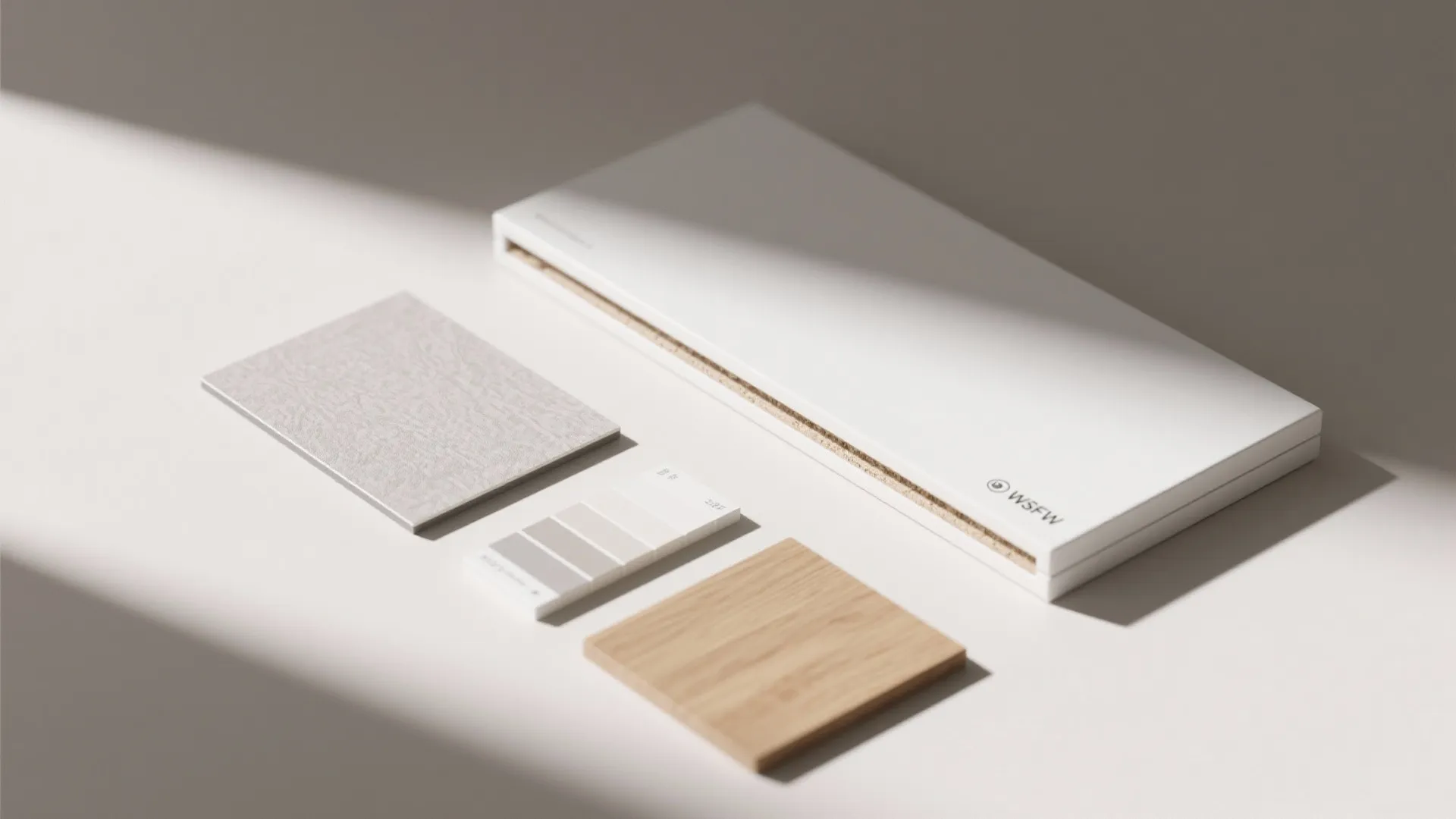 Interior design materials including wood sample fabric swatch and color palette on a white desk surface