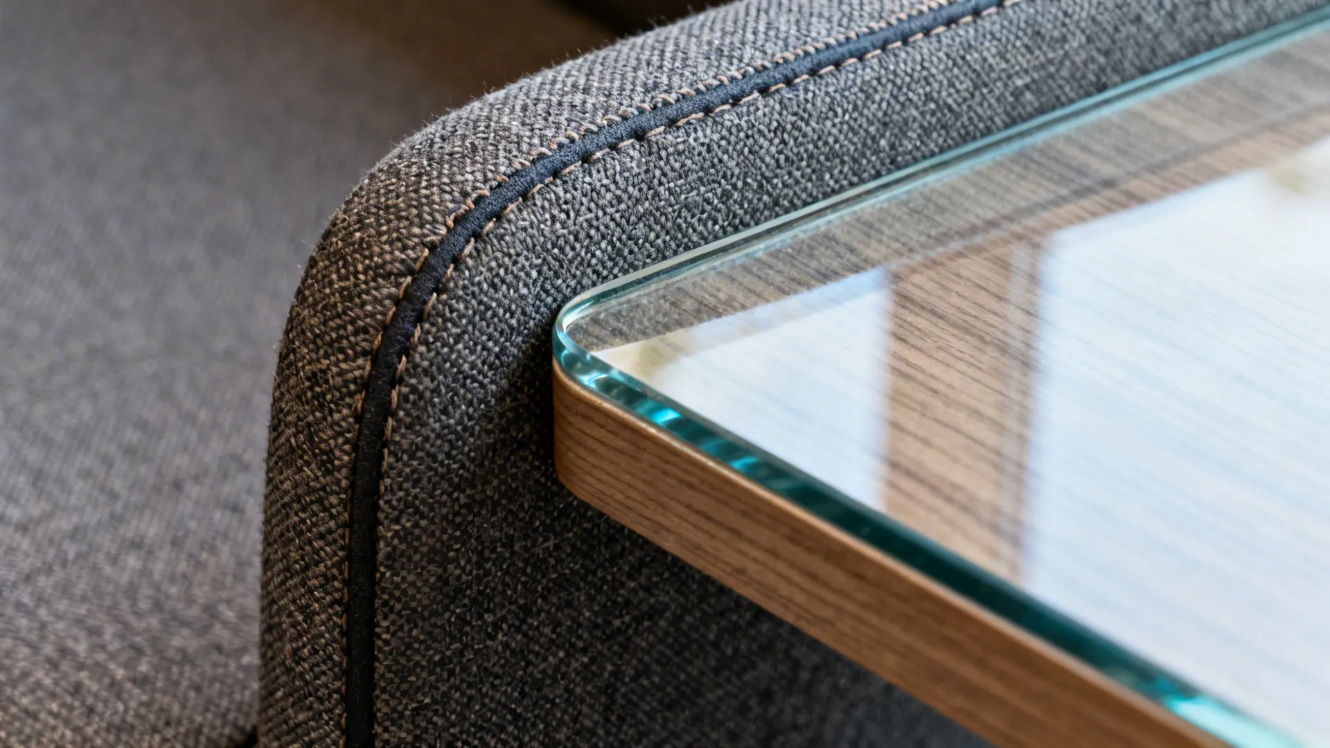 Macro of performance fabric upholstery with stitching beside glass and wood textures.