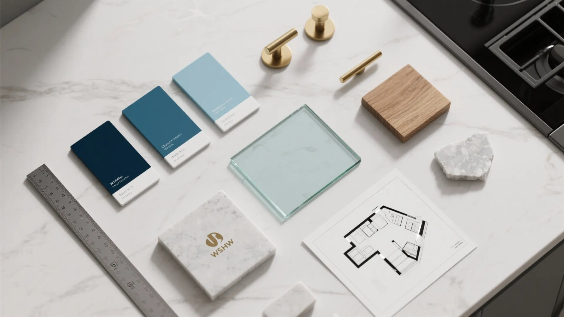 Top-down flatlay of paint swatches, brass pulls, wood and quartz samples for blue kitchen planning.