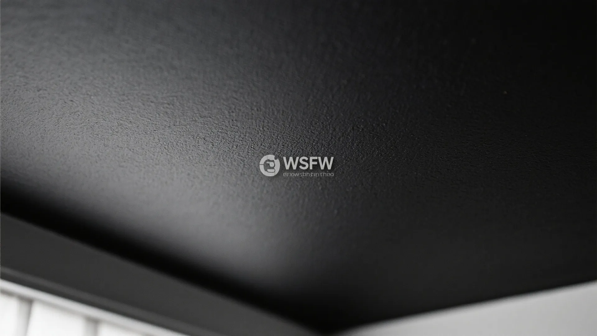 Close up view of a matte black paint finish on a smooth textured interior ceiling surface