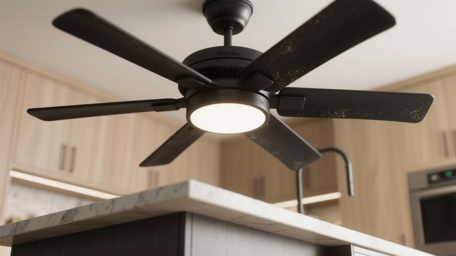 Modern black ceiling fan with light fixture installed above a kitchen island in bright room