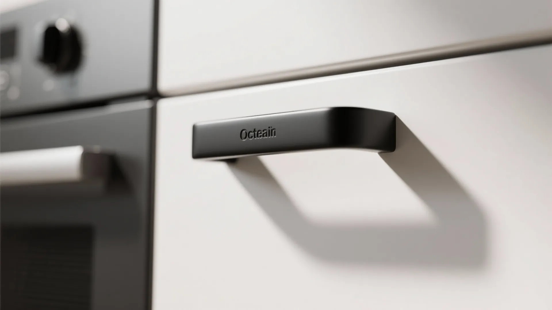 Close up of a matte black cabinet handle on a white drawer in a modern kitchen