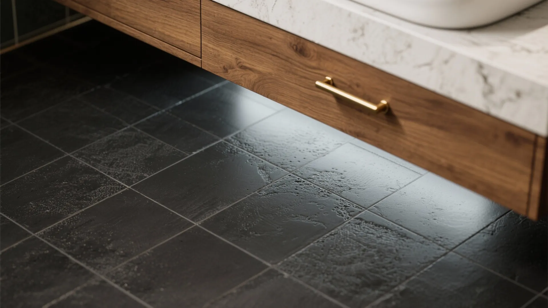 Close up of wooden bathroom cabinet with gold handle and dark grey floor tile texture