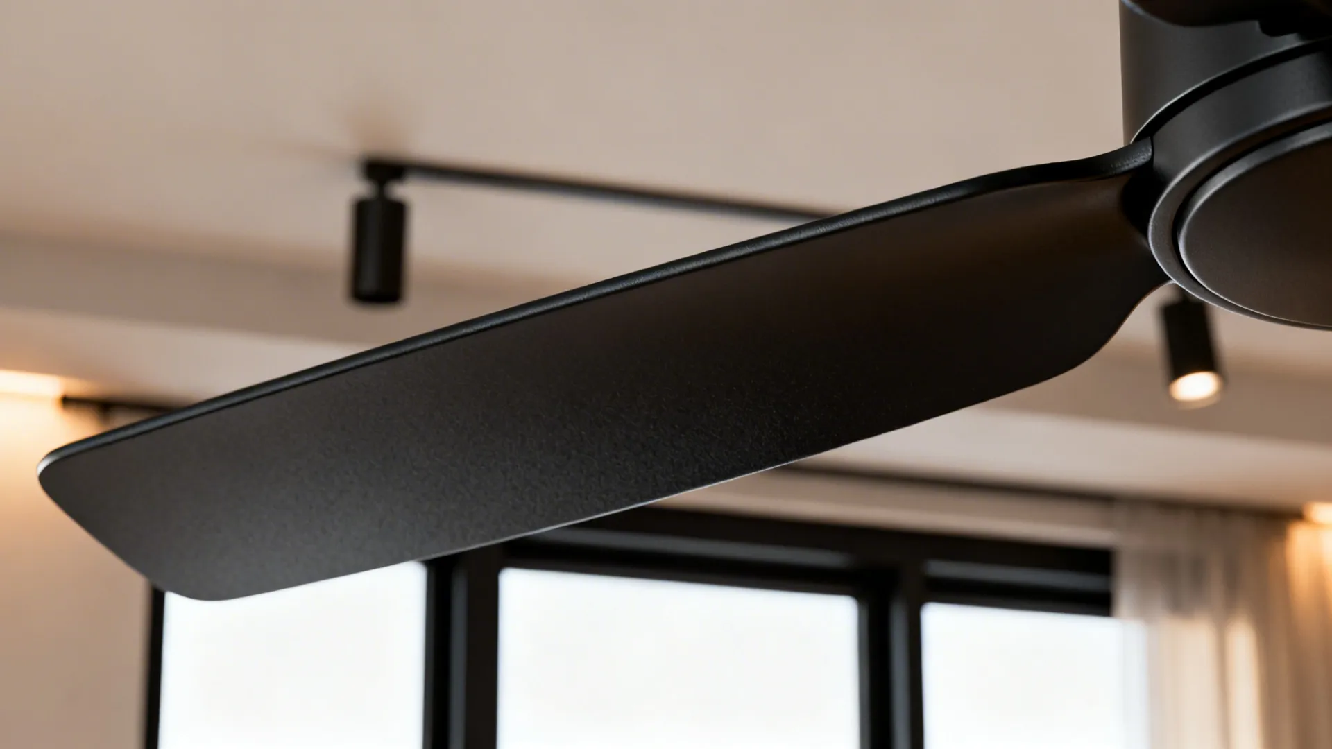 Close-up of a matte black ceiling fan blade and motor with matching matte fixtures