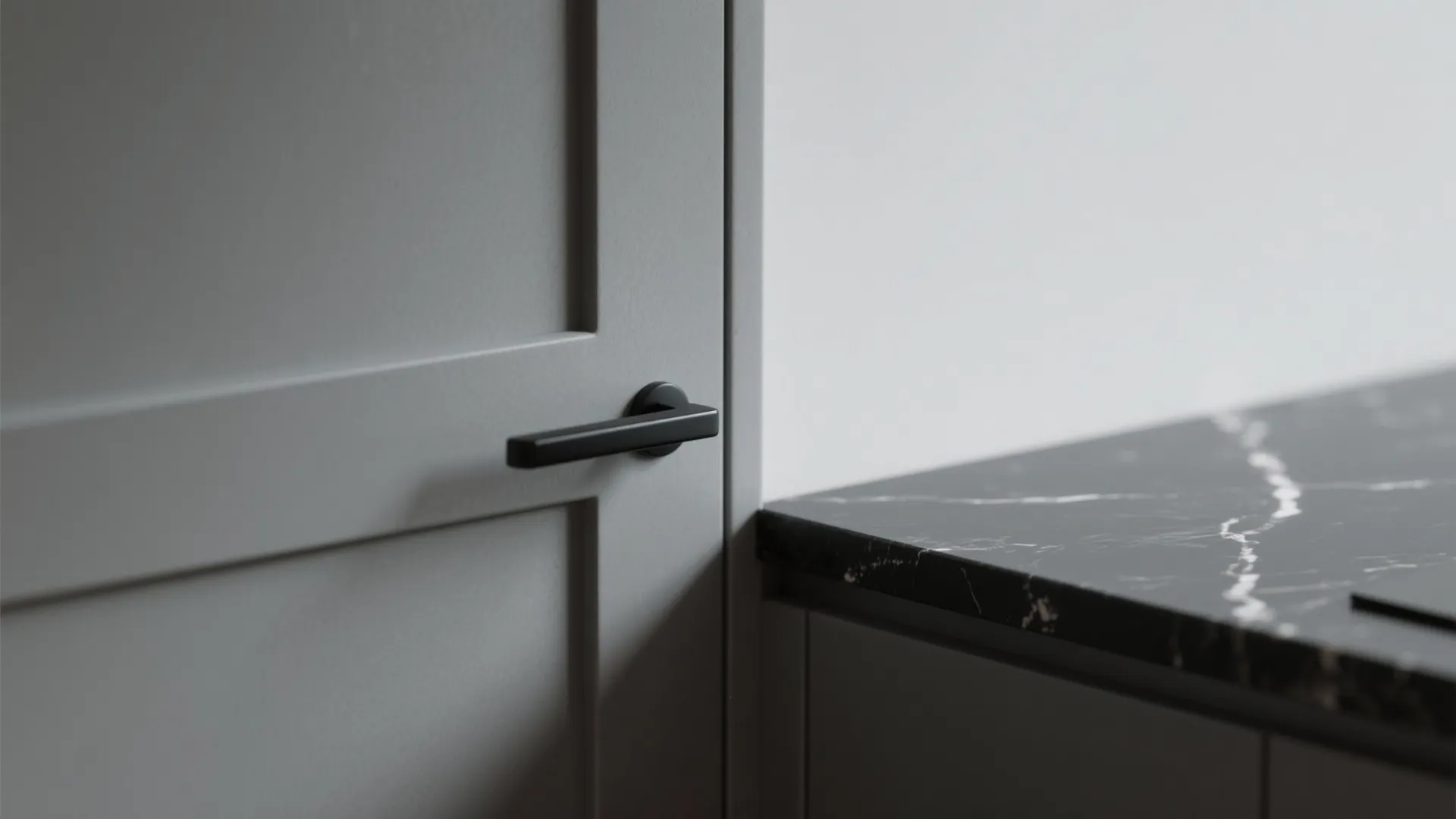 Close-up of matte gray cabinet and glossy black countertop showing texture and reflection.