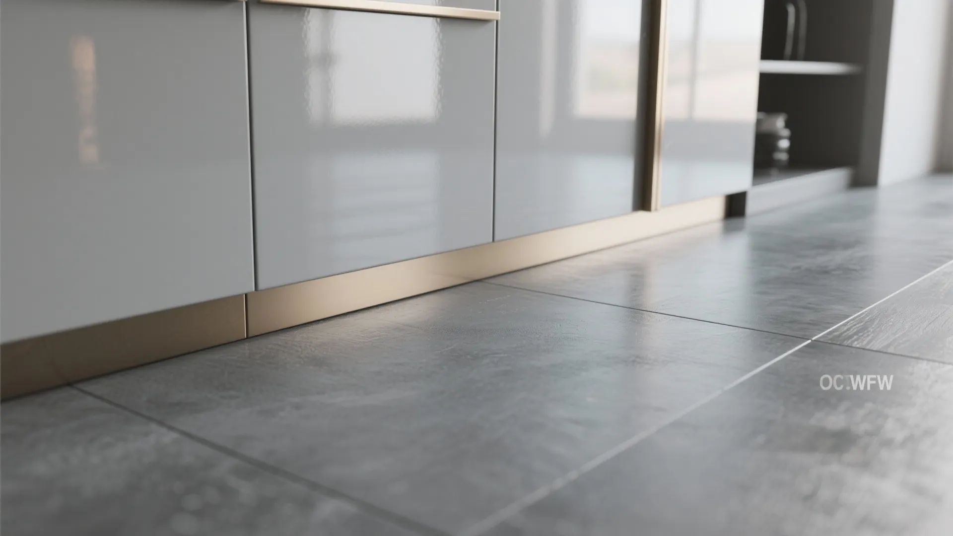 White glossy kitchen cabinets with gold baseboard trim on dark grey tiled floor indoor setting