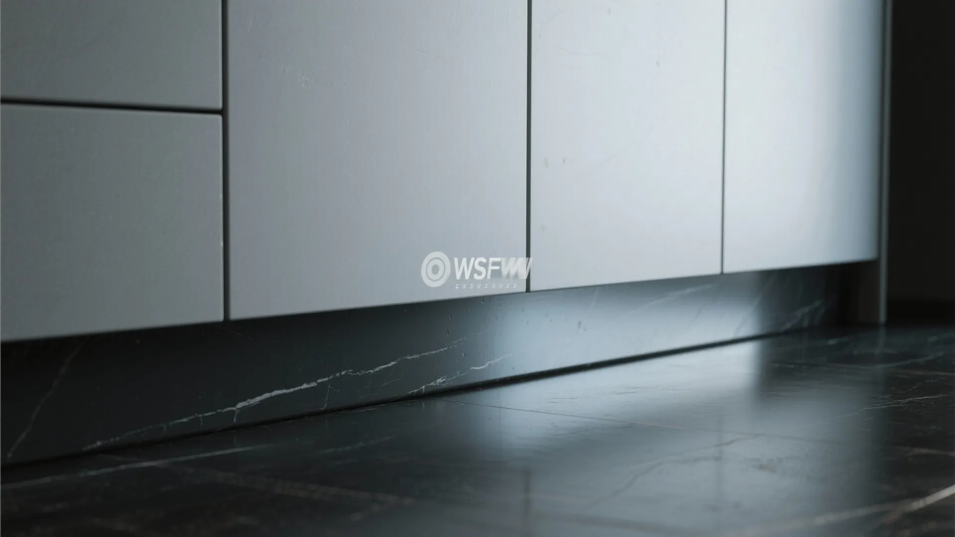 Modern white kitchen cabinets above black marble base and dark stone floor with soft light