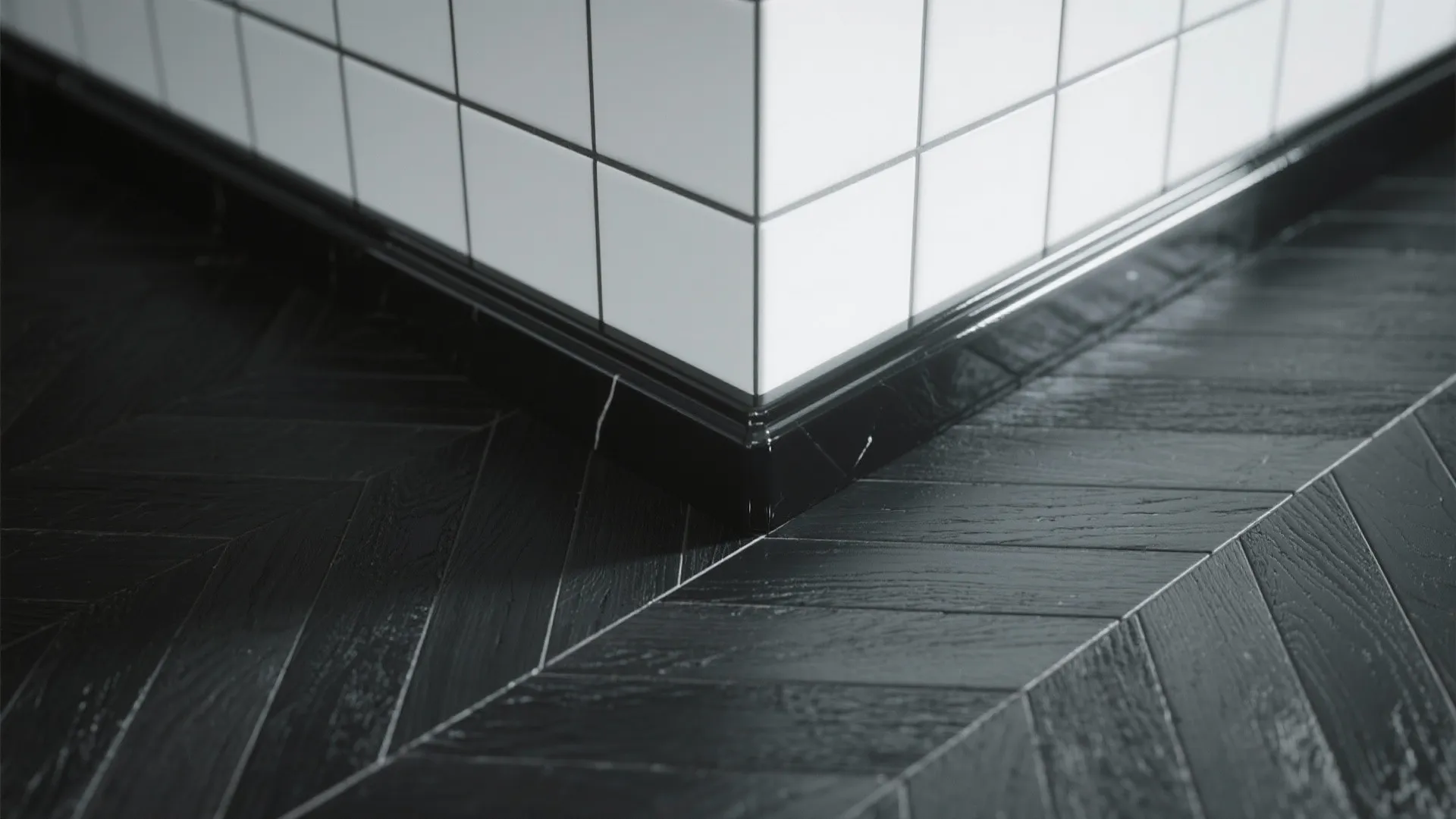 Close-up of matte black herringbone tile with glossy black trim showing texture contrast and grout detail.