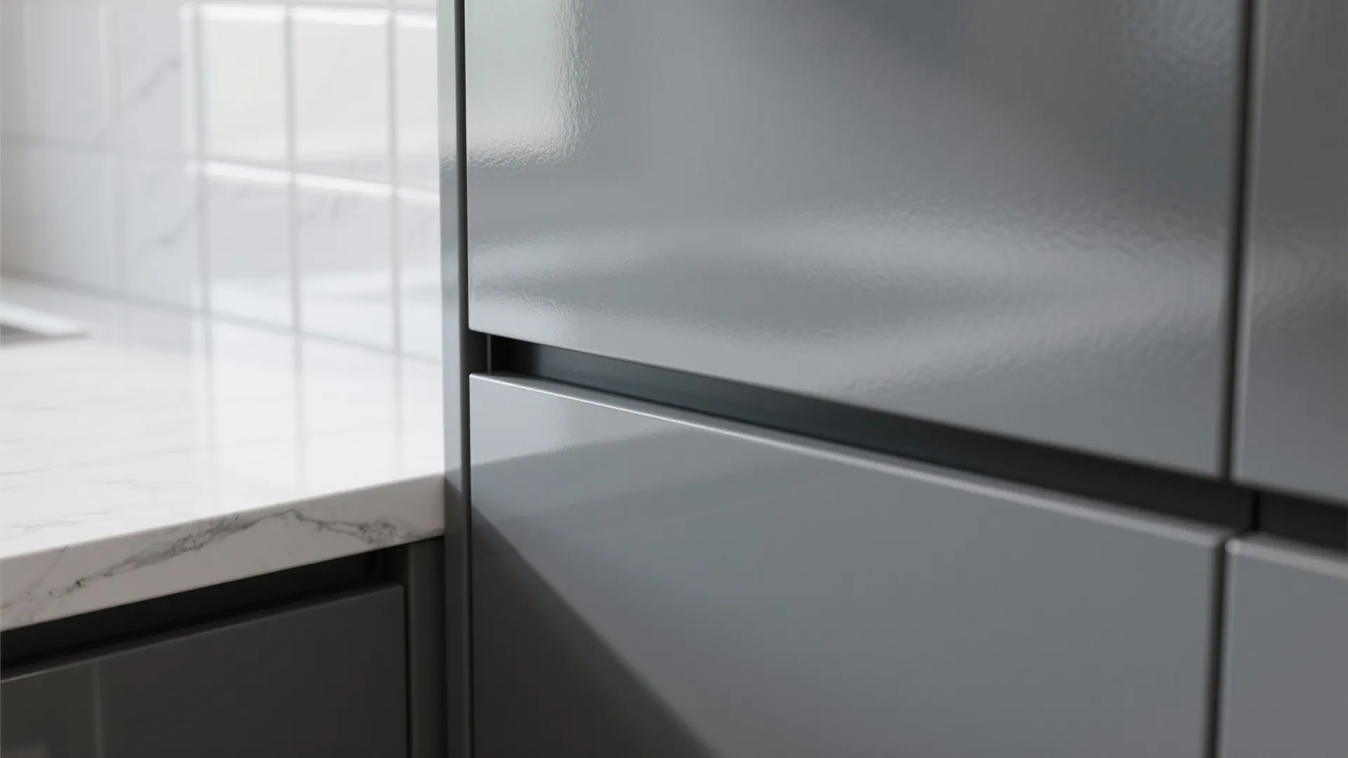 Close up of glossy gray kitchen cabinet doors next to a white marble countertop surface