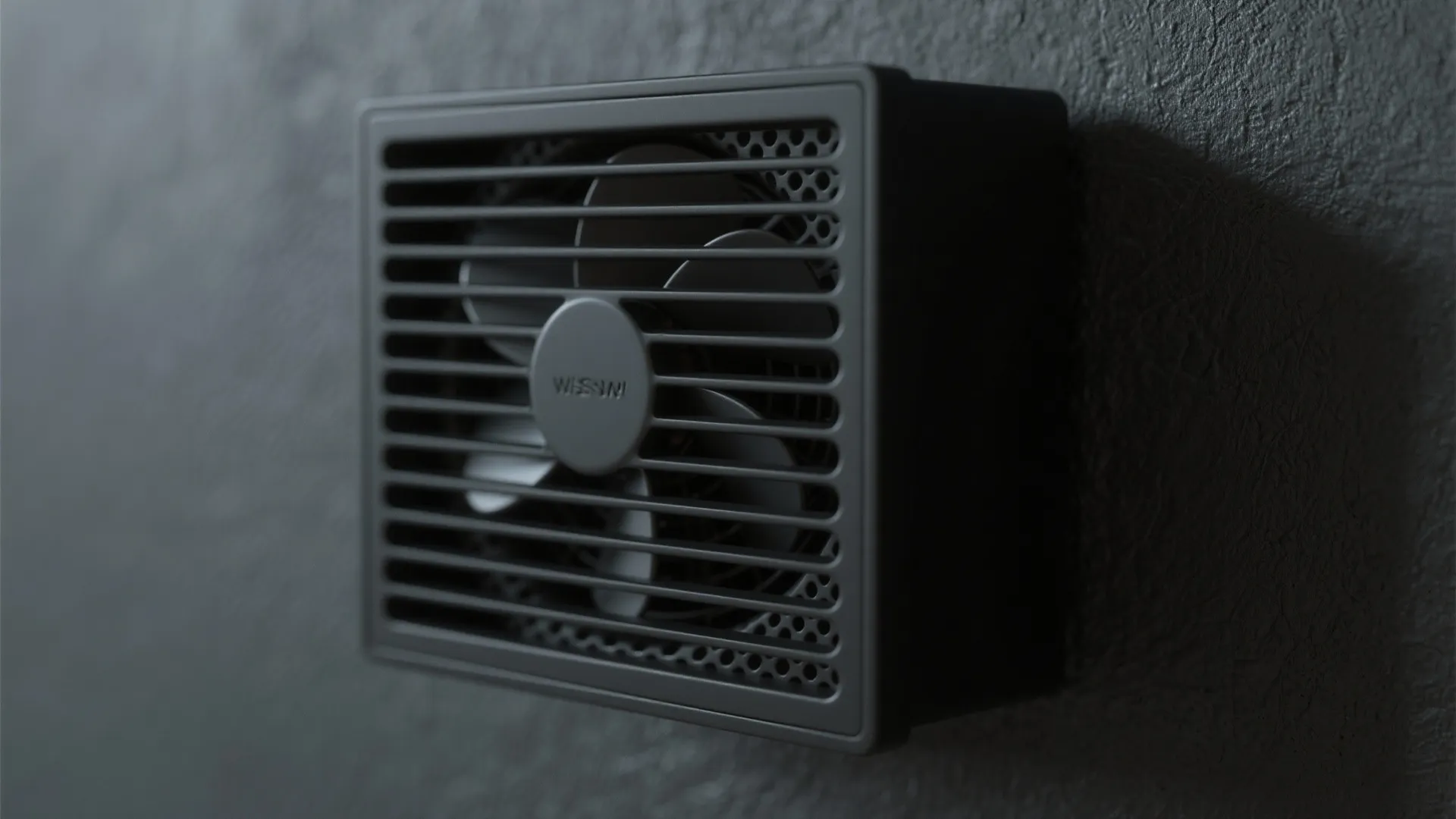 Macro of a matte black wall fan grille showing refined powder-coated texture and slim profile.