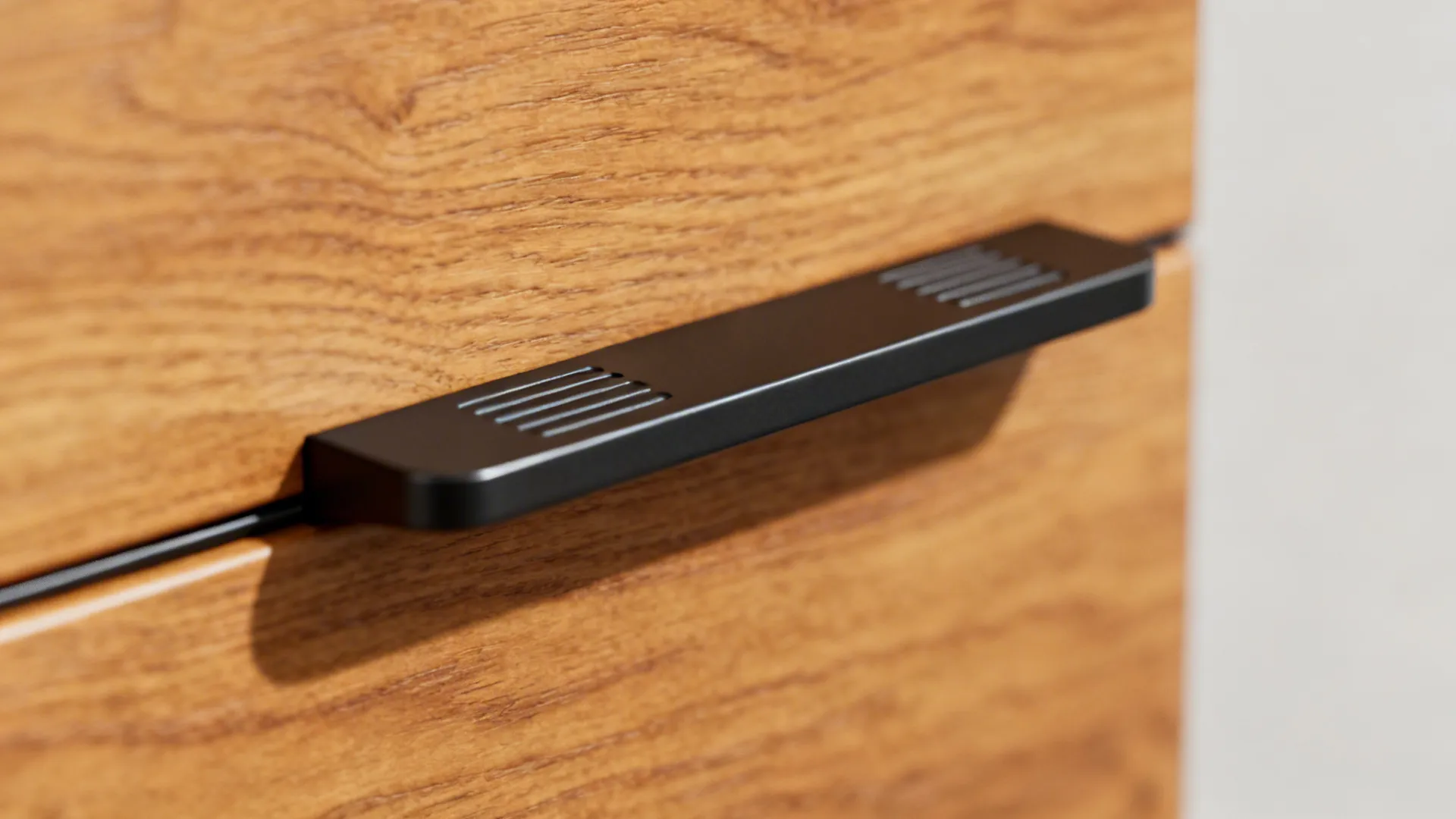 Close-up of matte black hardware installed on honey oak cabinet showing texture and finish.