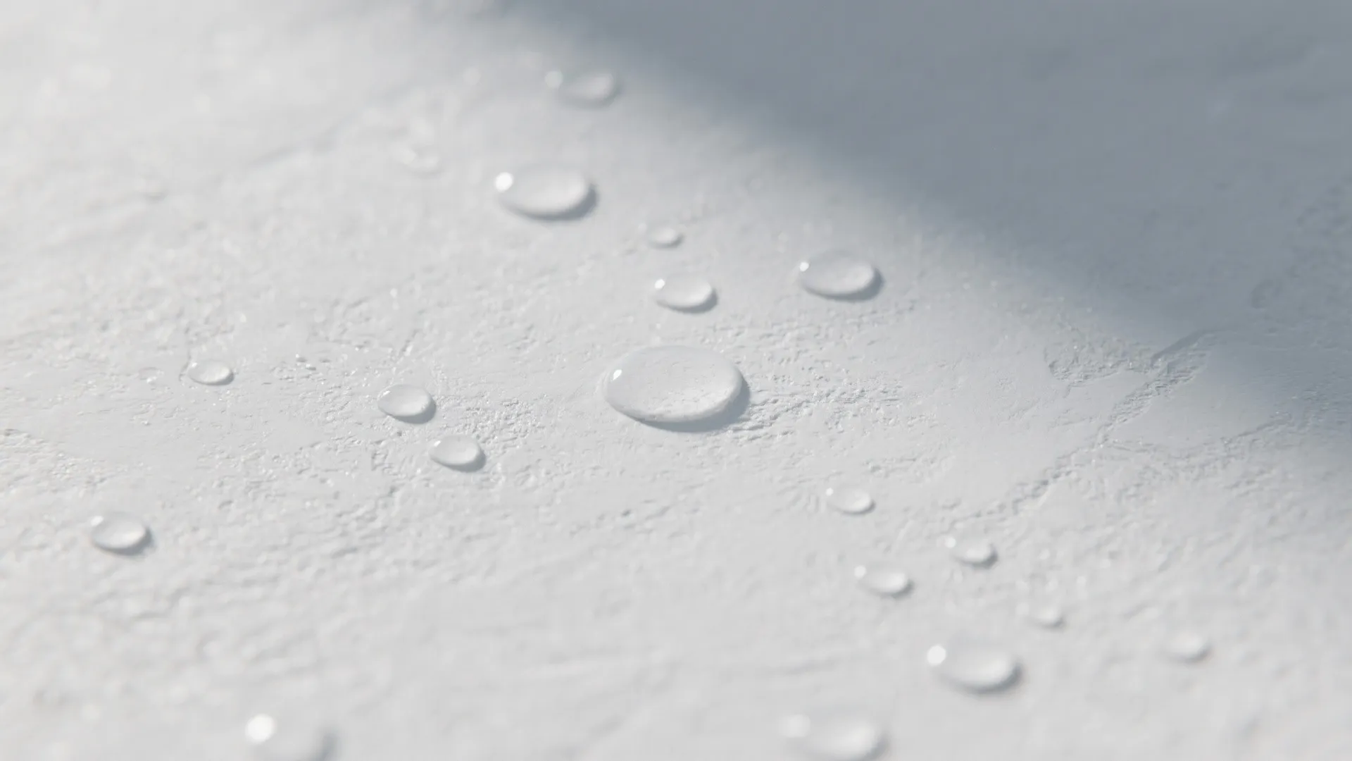 Close-up of subtle textured white microcement with matte protective finish