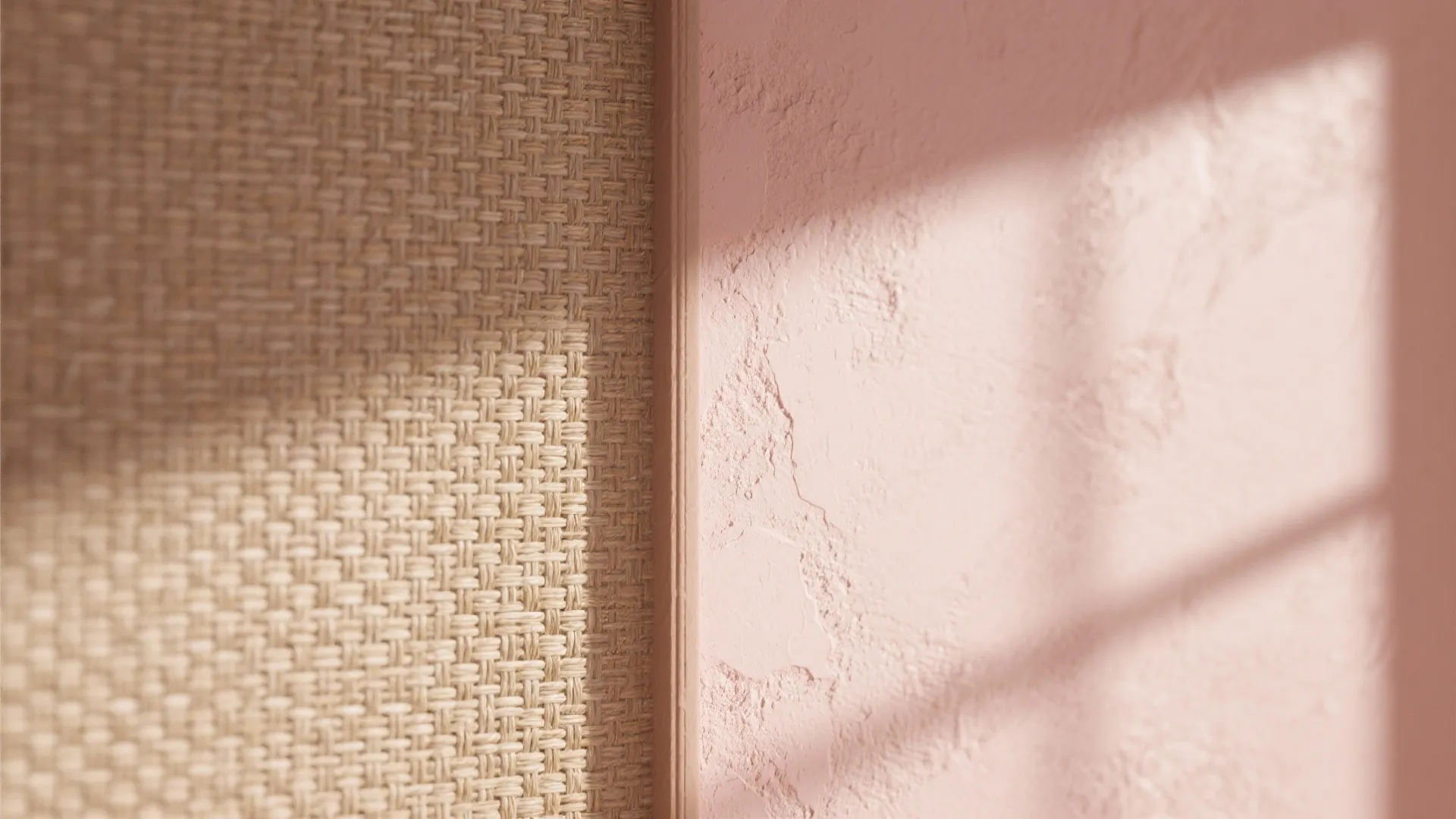 Close up view of woven wall covering material next to pink textured wall with window light