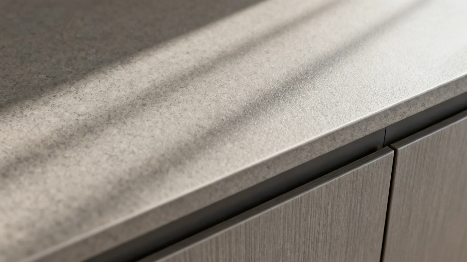 Close up of grey matte countertop with shadows from window light and modern grey cabinets