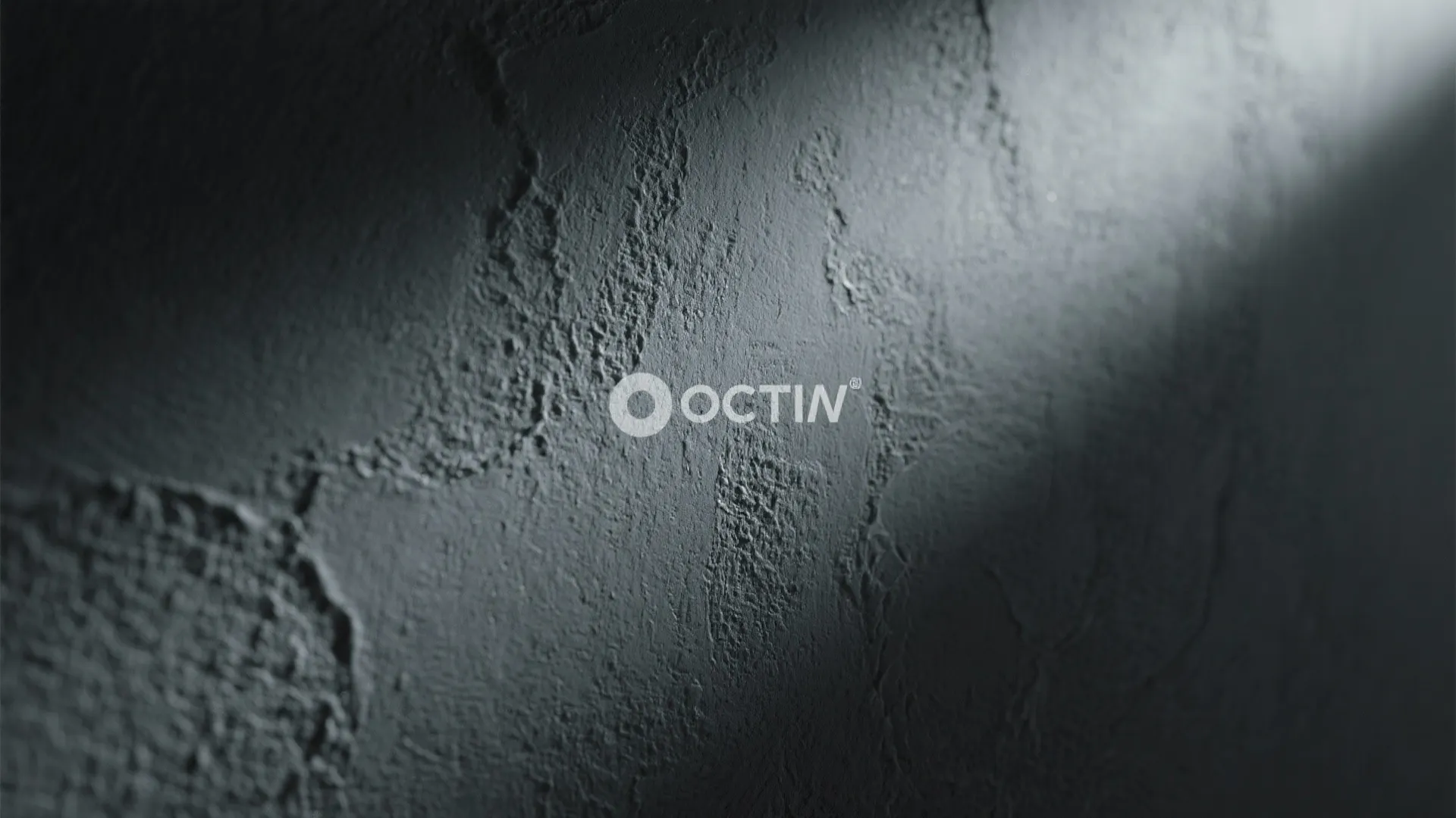 Close up view of dark grey textured wall with light ray hitting the rough surface area