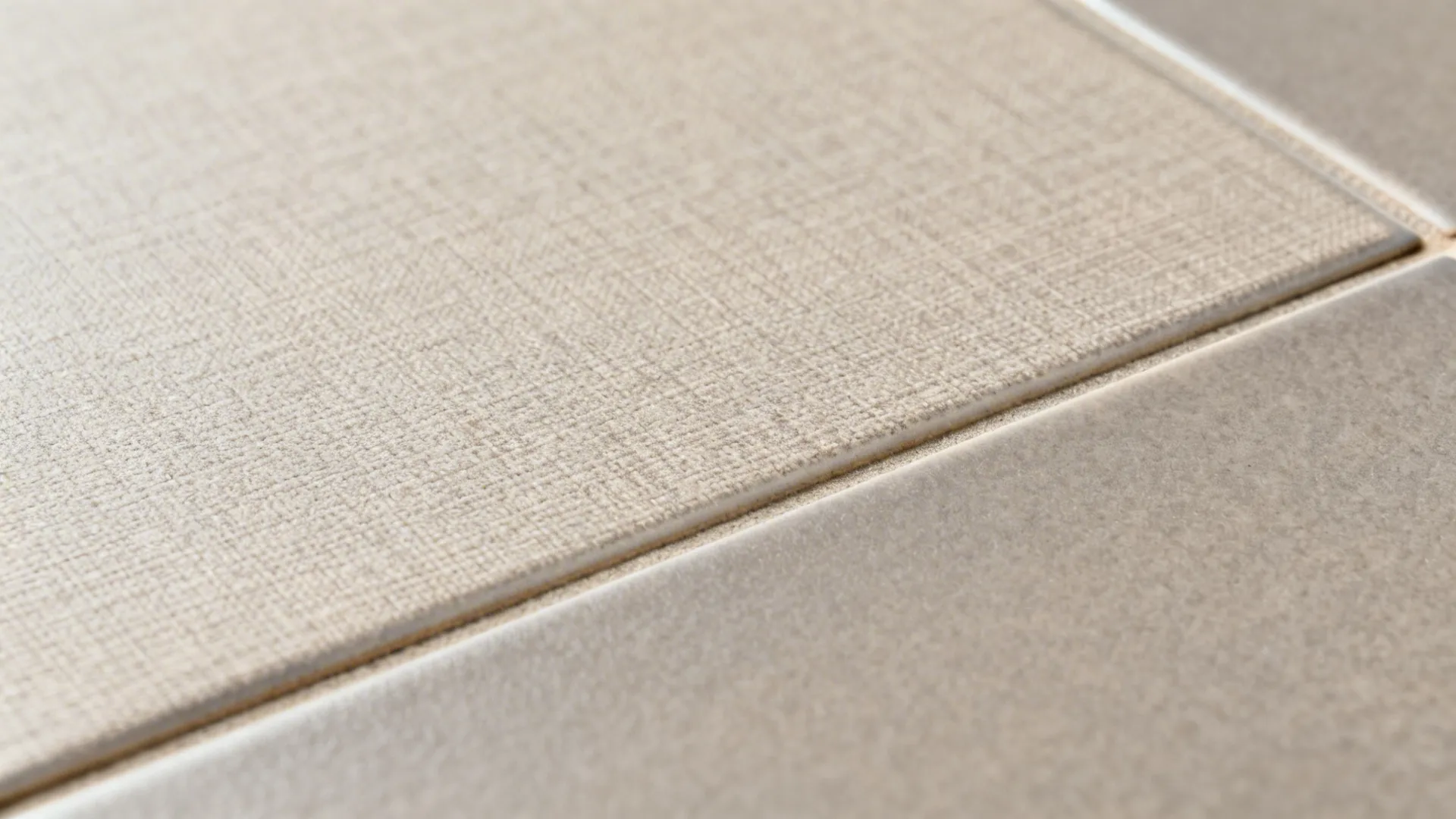 Macro of matte linen-weave tile texture with soft satin finish and clean grout line.
