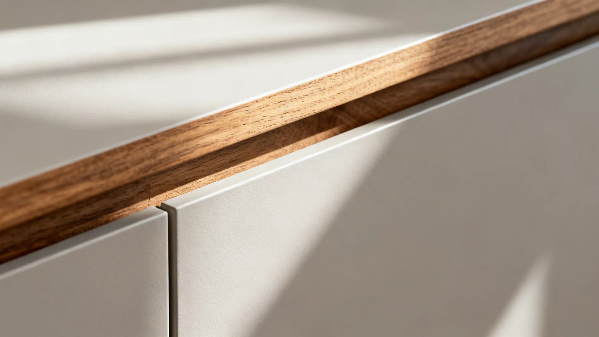 Detailed view of white kitchen cabinet door with wooden top edge under soft natural morning sunlight