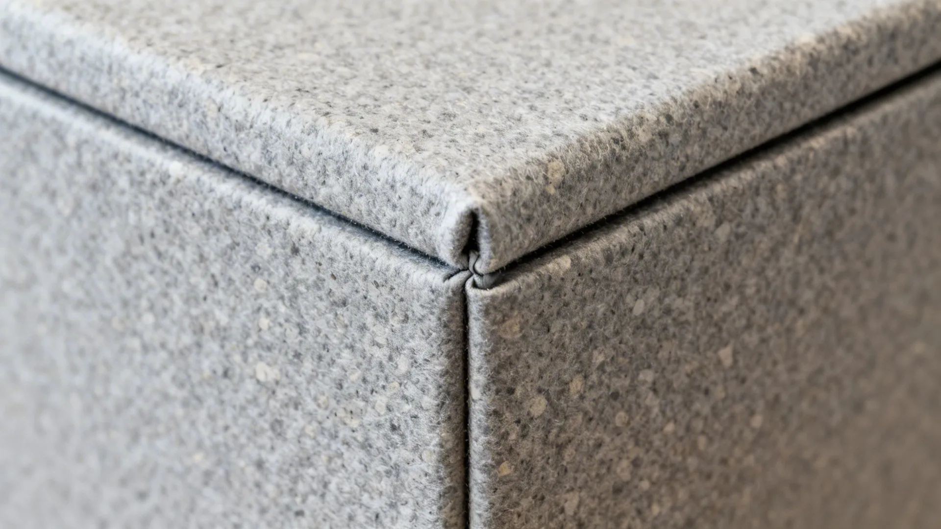 Macro of matte gray vinyl wrap on a dishwasher corner with clean, precise edge and soft texture.