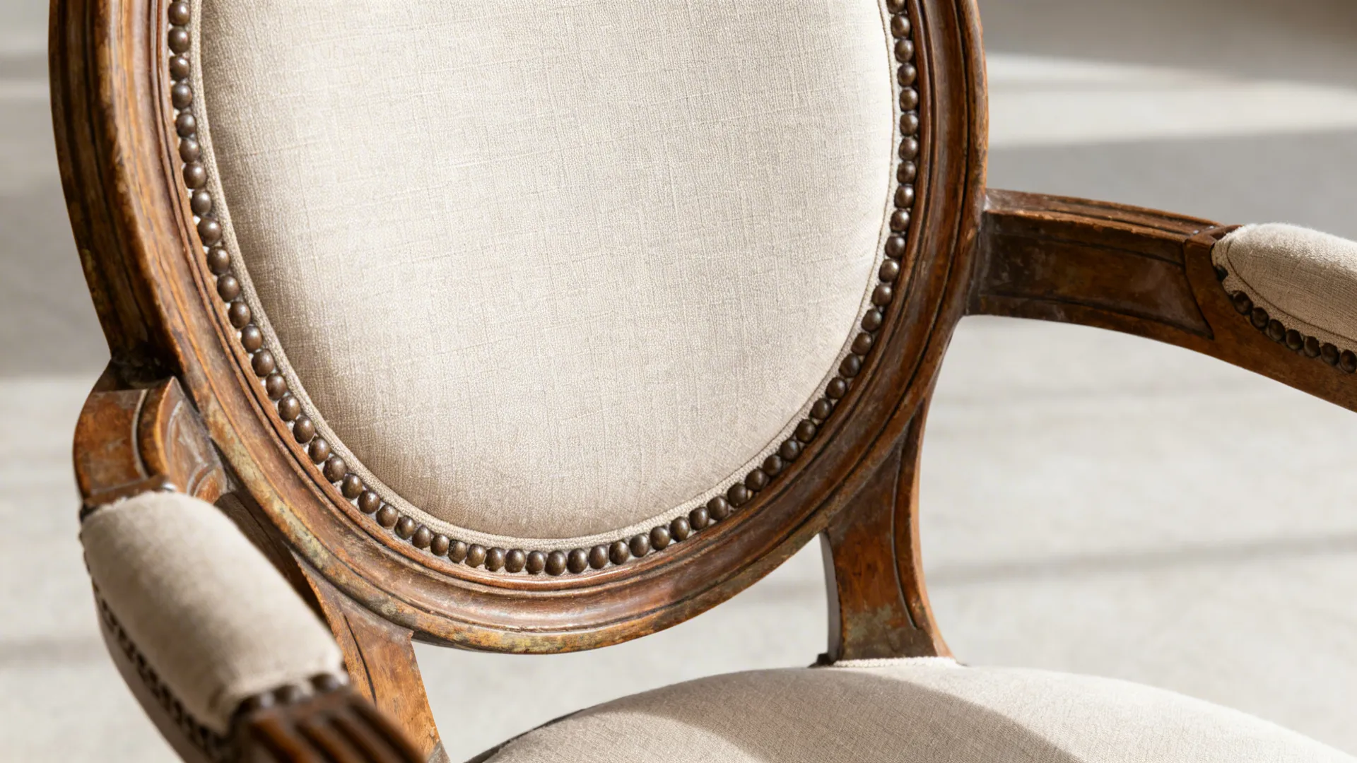 Macro of carved medallion chair back with caning and linen upholstery.