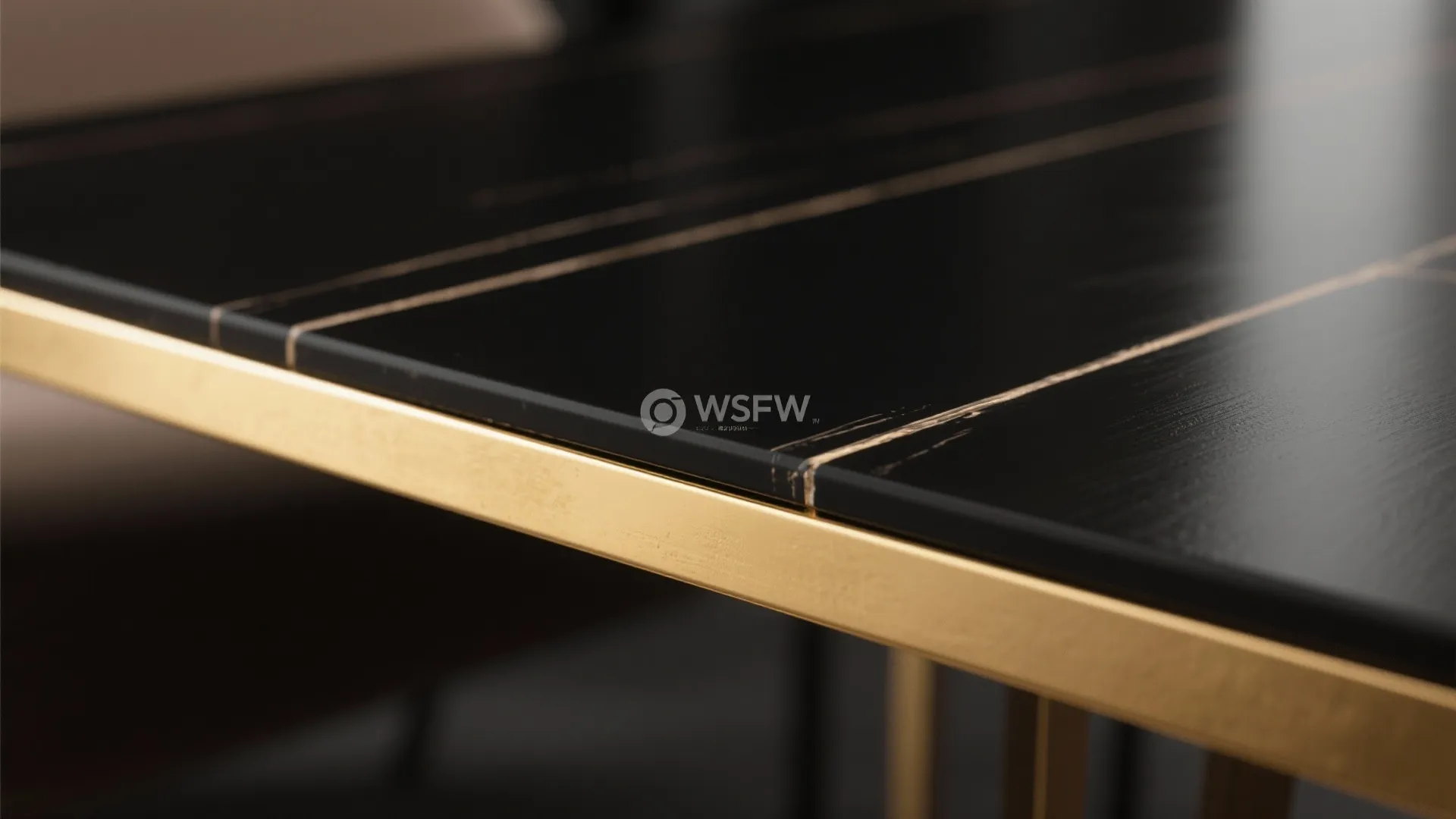 Close up view of black marble tabletop with gold metal edge detail and faint white veins