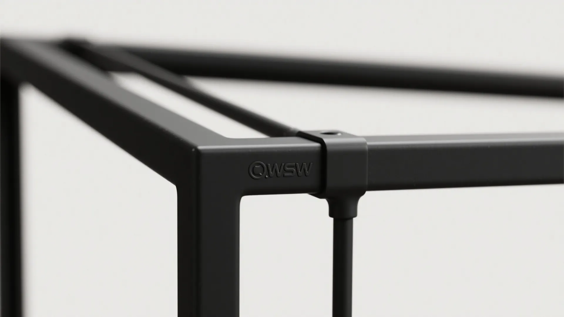 Close-up of matte powder-coated black metal frame showing texture and weld details.