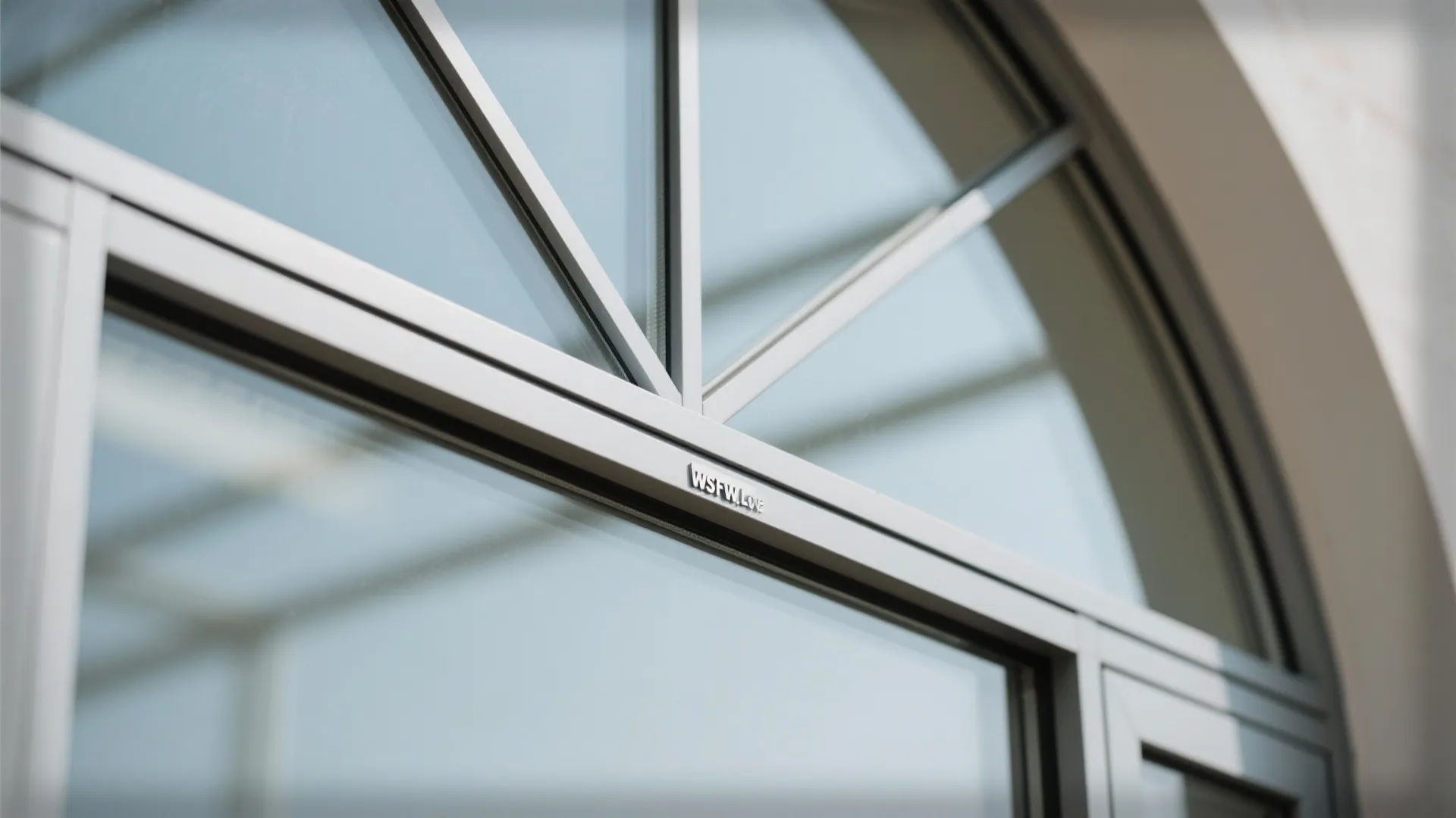 Close-up of slim powder-coated aluminum frame meeting curved low-E glass at an arched head.