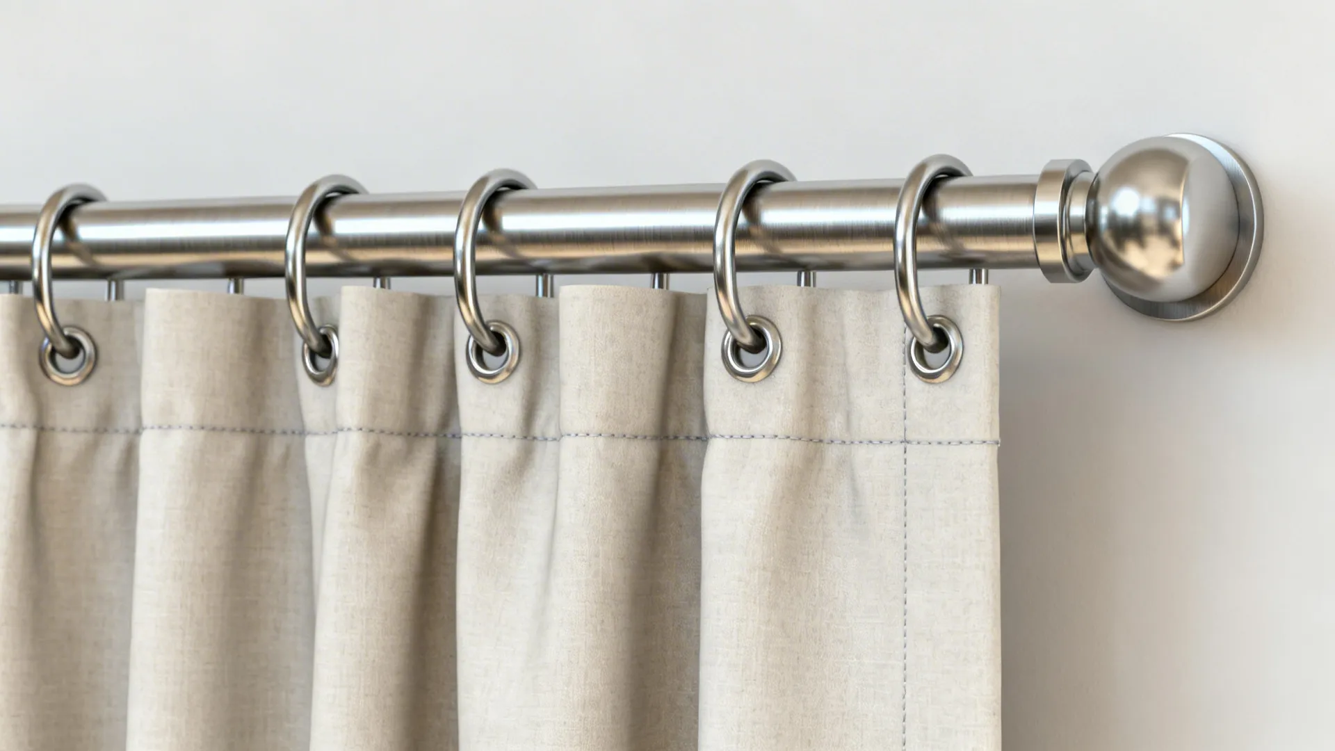Close-up of brushed metal grommet and neat curtain folds in a modern living room