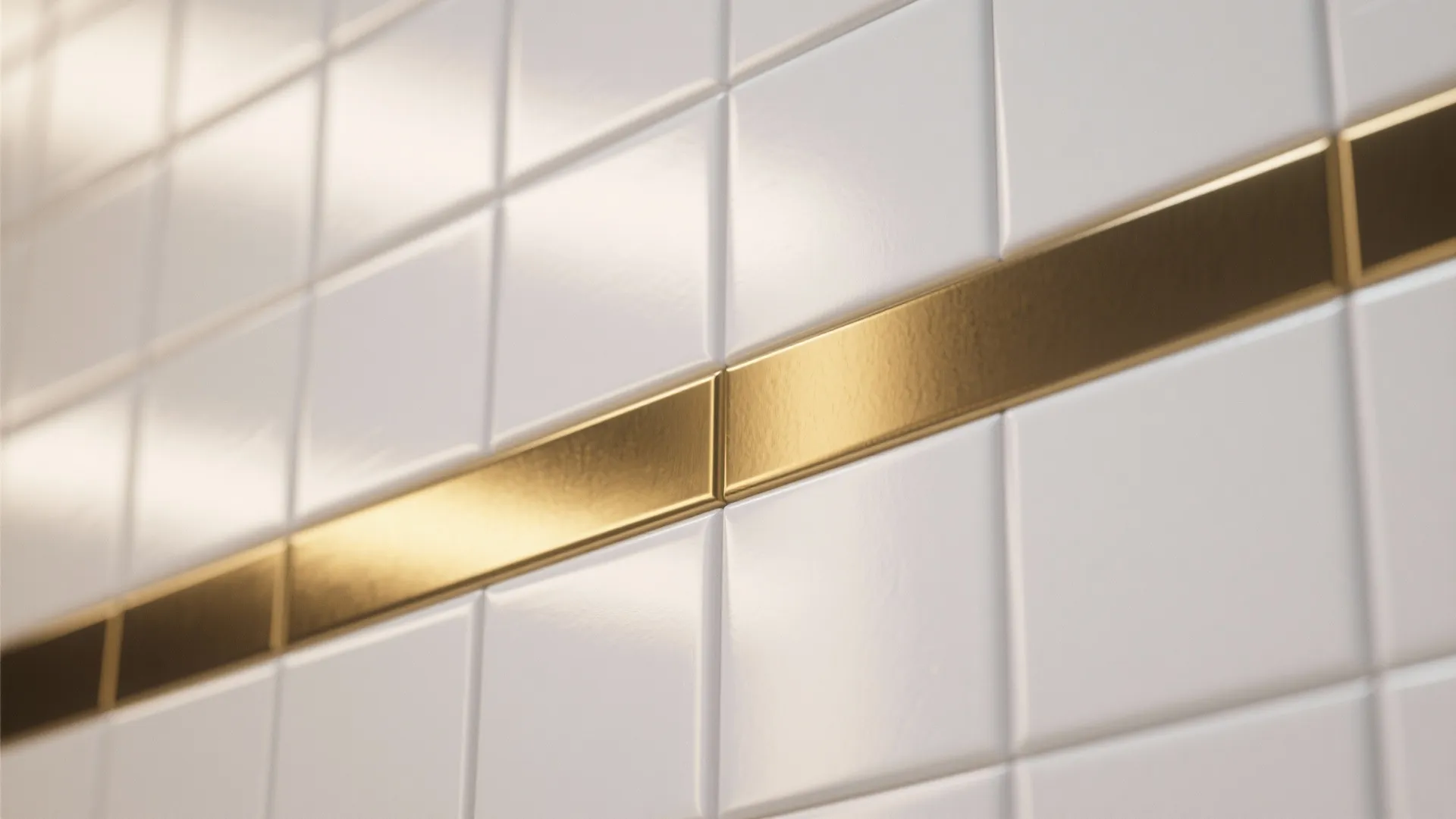 Close up of white square wall tiles featuring a horizontal gold metal strip for decorative detail