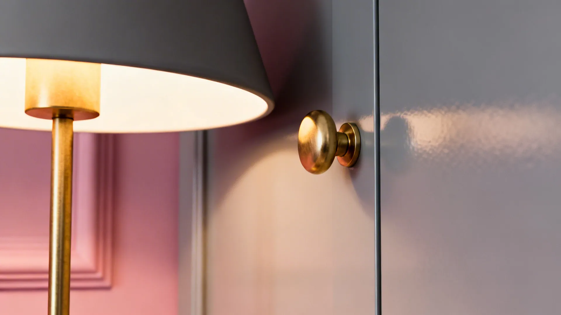 Brass lighting and hardware elevating a pink-and-gray living room palette.
