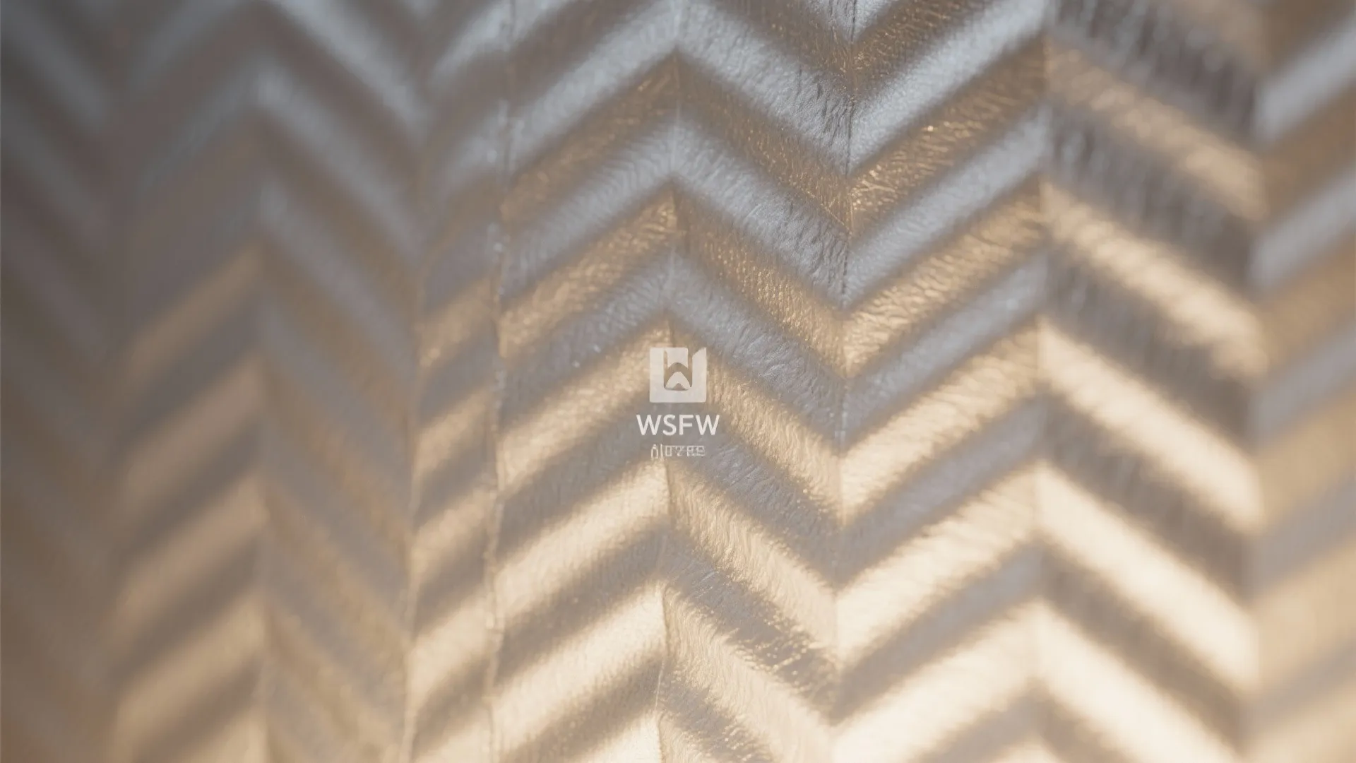 Close up of textured metallic wall paper with a shiny silver and gold zigzag pattern design