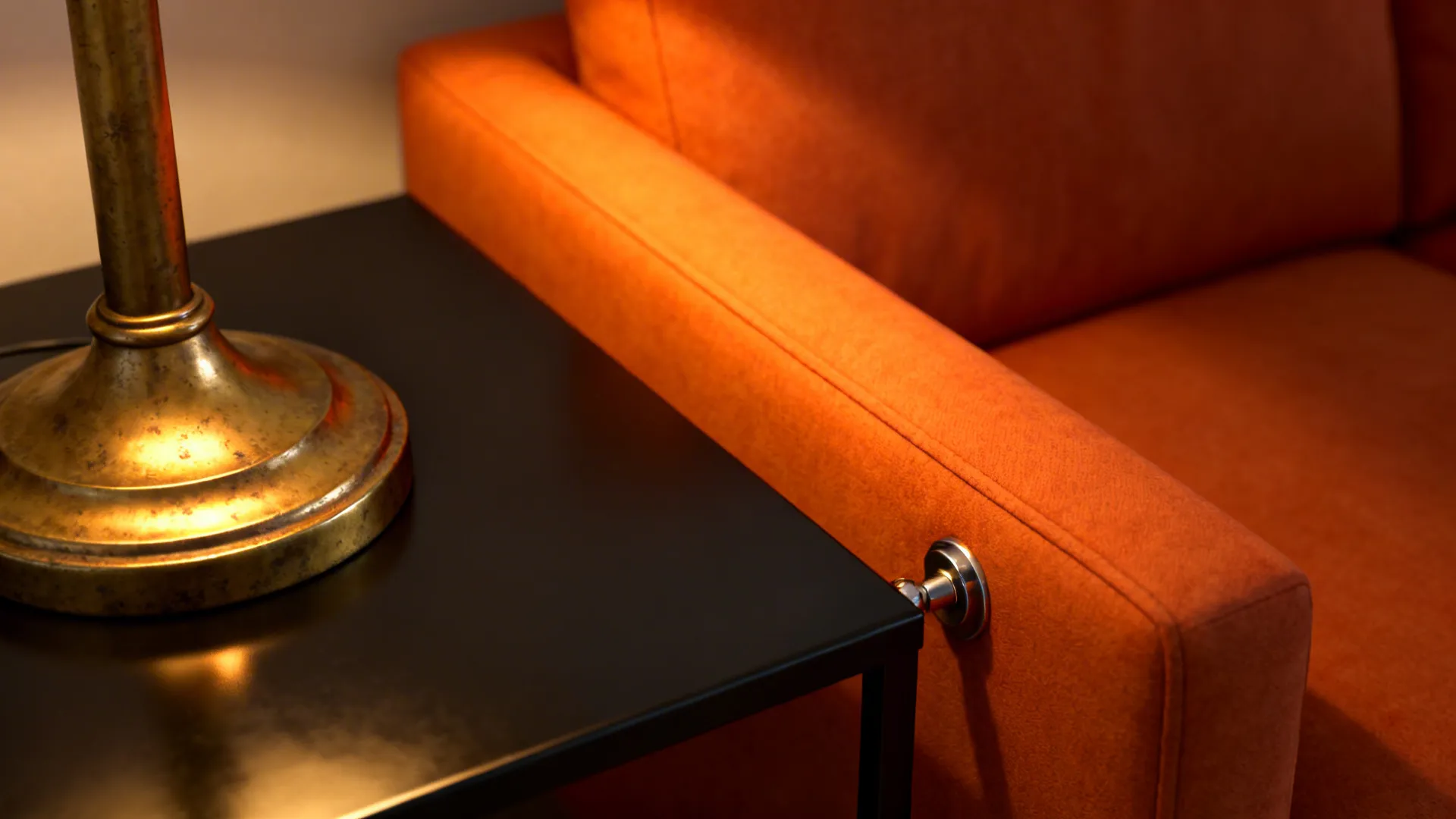 Brass floor lamp and matte black table beside an orange sofa, highlighting metallic touches.