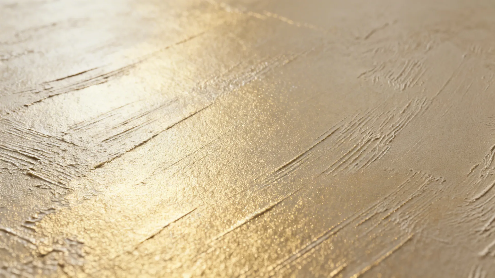 Macro of champagne metallic plaster with satin sheen and subtle trowel strokes.