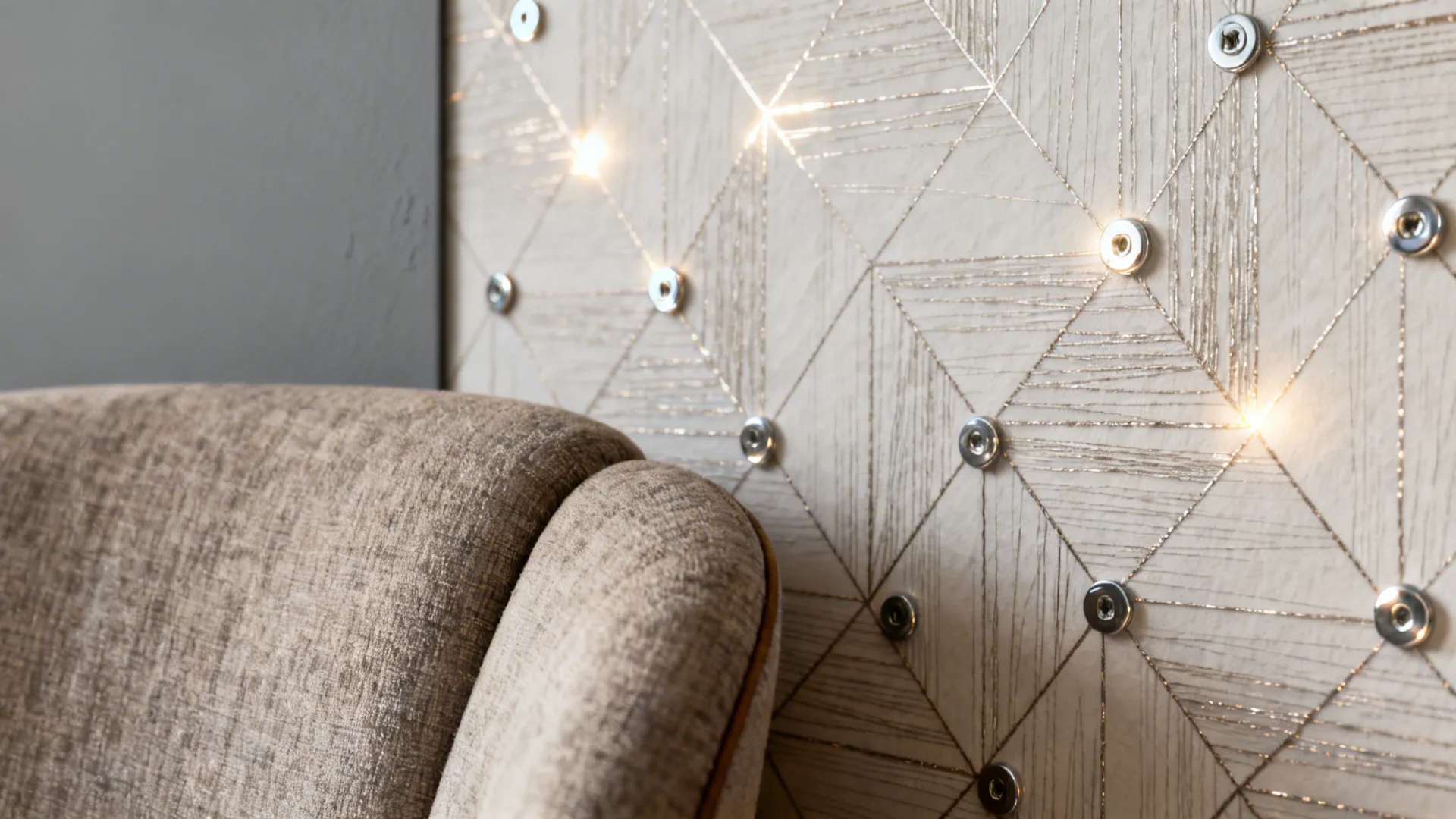Textured geometric wallpaper with subtle metallic thread reflecting light in a cosy nook.