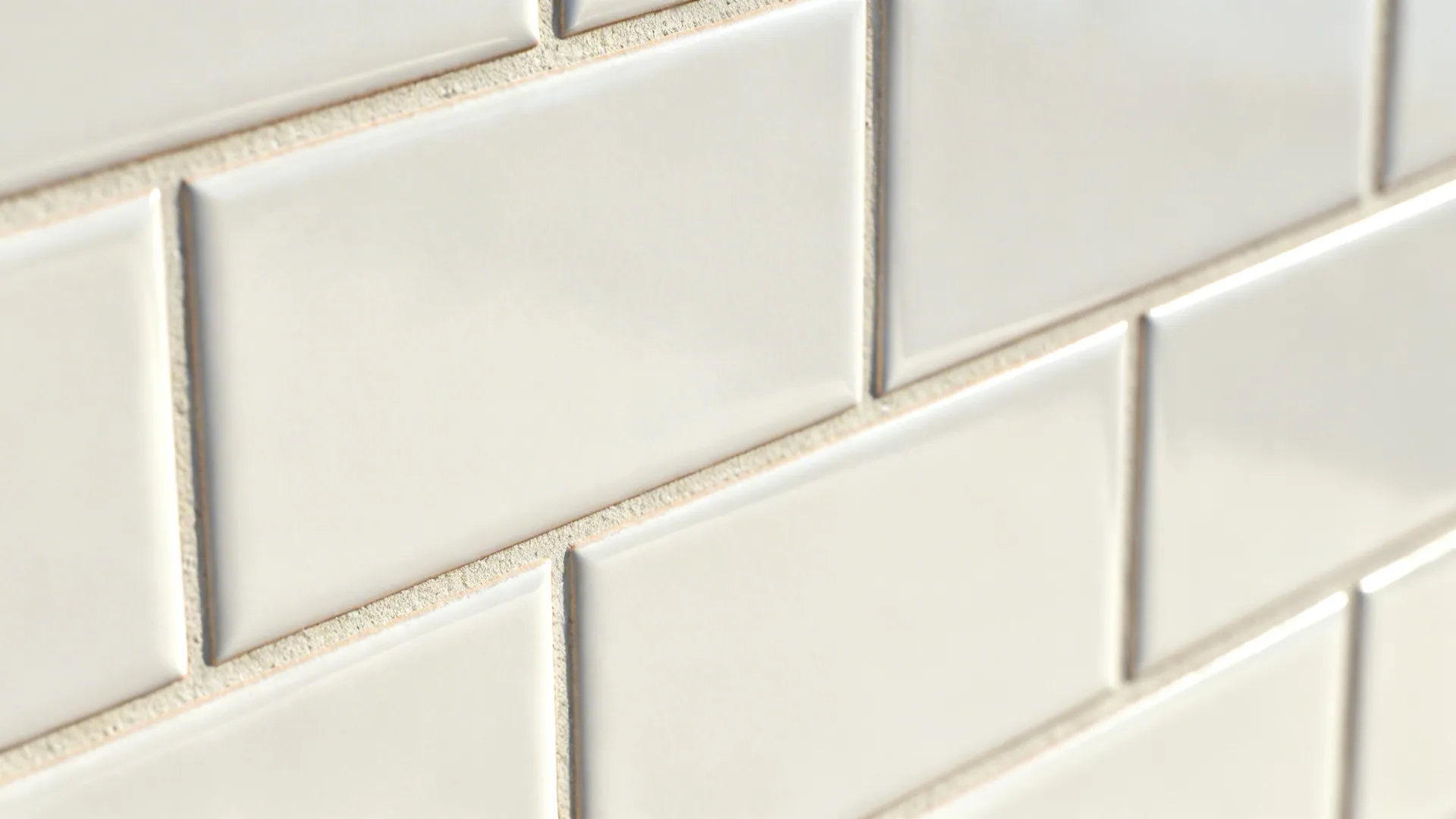 Close up view of white rectangular wall tiles with grey grout lines and smooth finish