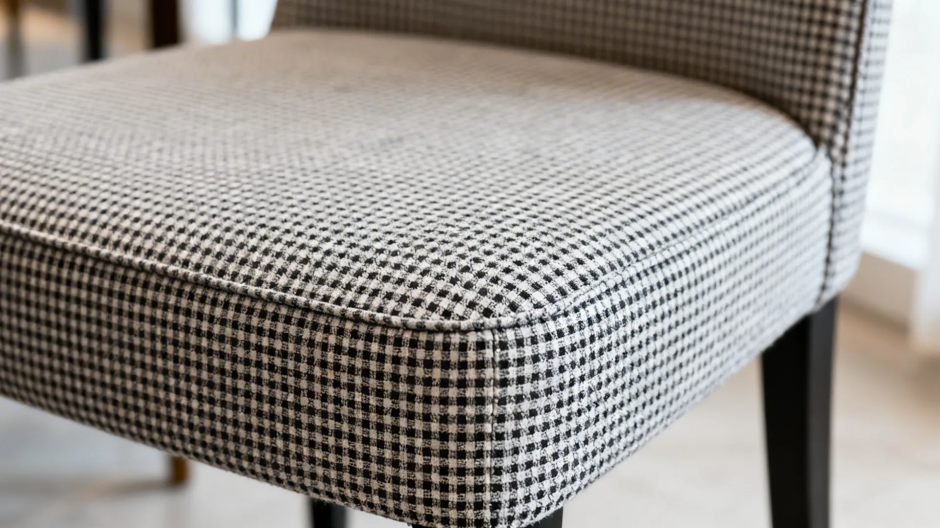 Macro detail of a micro-gingham seat cover showing 3–5 mm checks and crisp stitching on an armless chair.