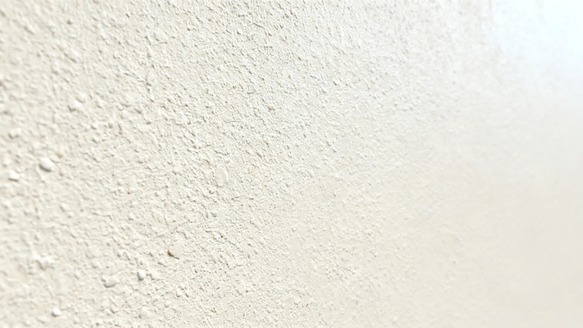 Macro of fine-grain micro-stucco with subtle eggshell sheen in soft daylight.